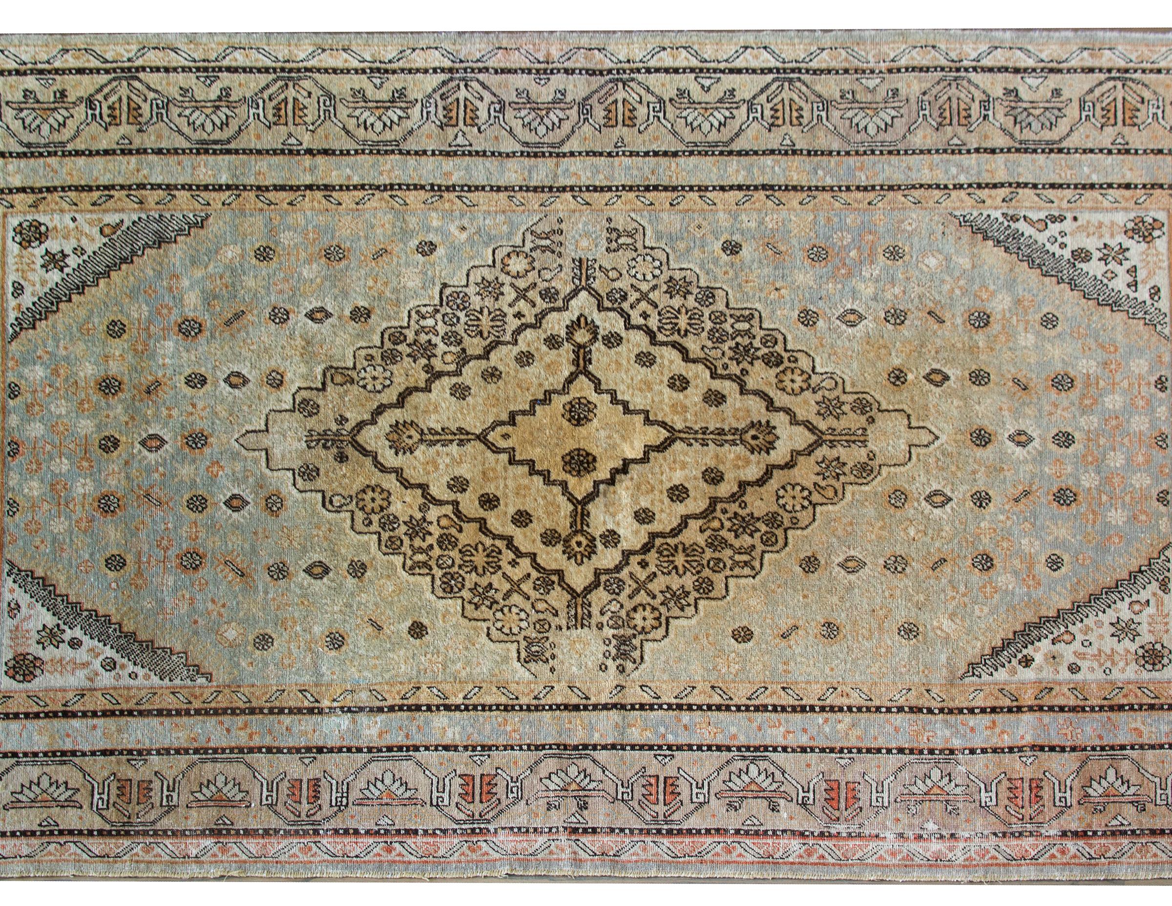 A beautiful early 20th century Central Asian Samarghand rug with a large central diamond medallion with myriad stylized flowers living against a field of more styled flowers, and surrounded by a complex border composed of multiple floral and