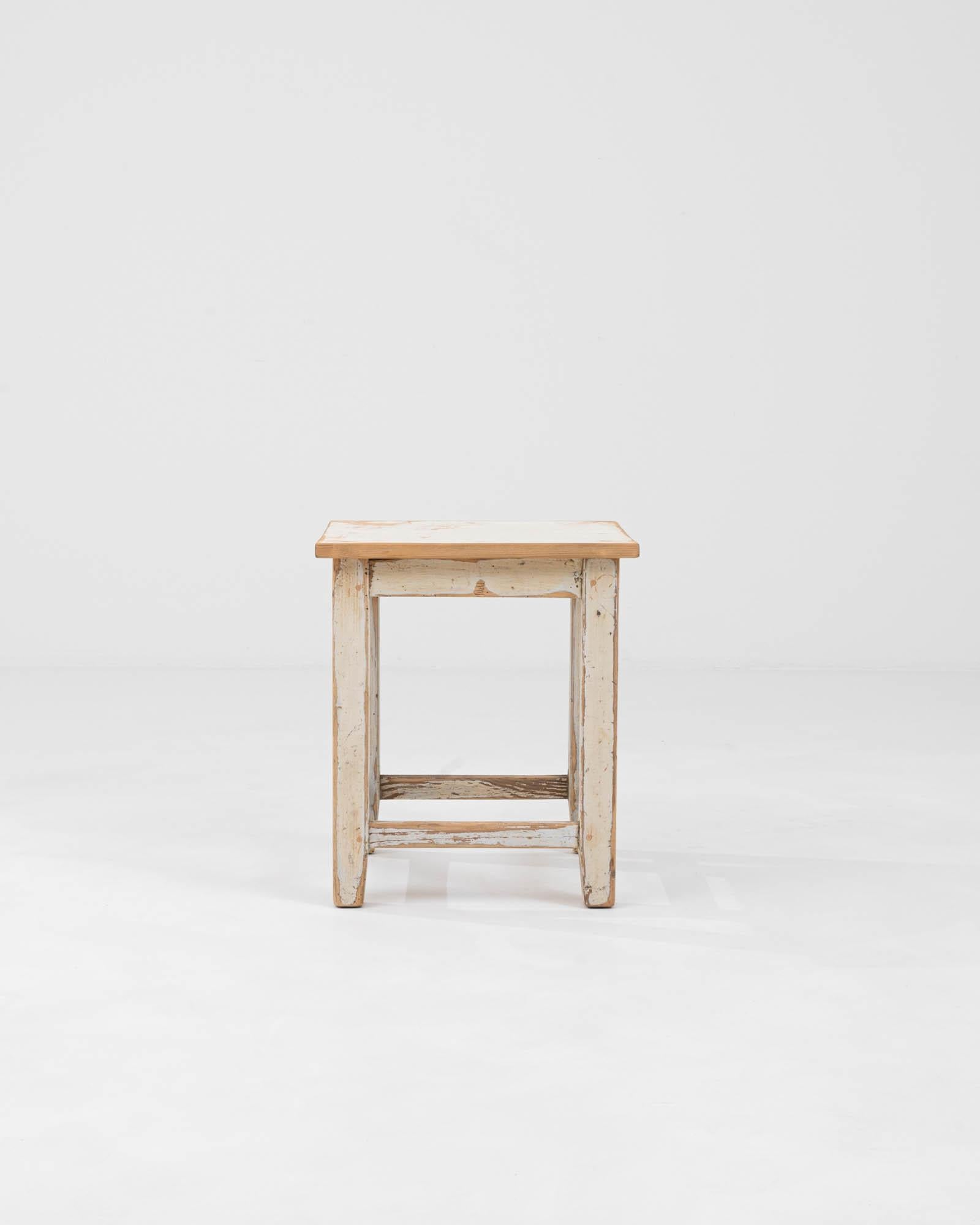 Cet authentique tabouret d'Europe centrale du début du XXe siècle témoigne de la beauté intemporelle du design utilitaire. Fabriqué à partir de bois qui a gracieusement vieilli, le tabouret porte son histoire dans les couches de patine et les traces