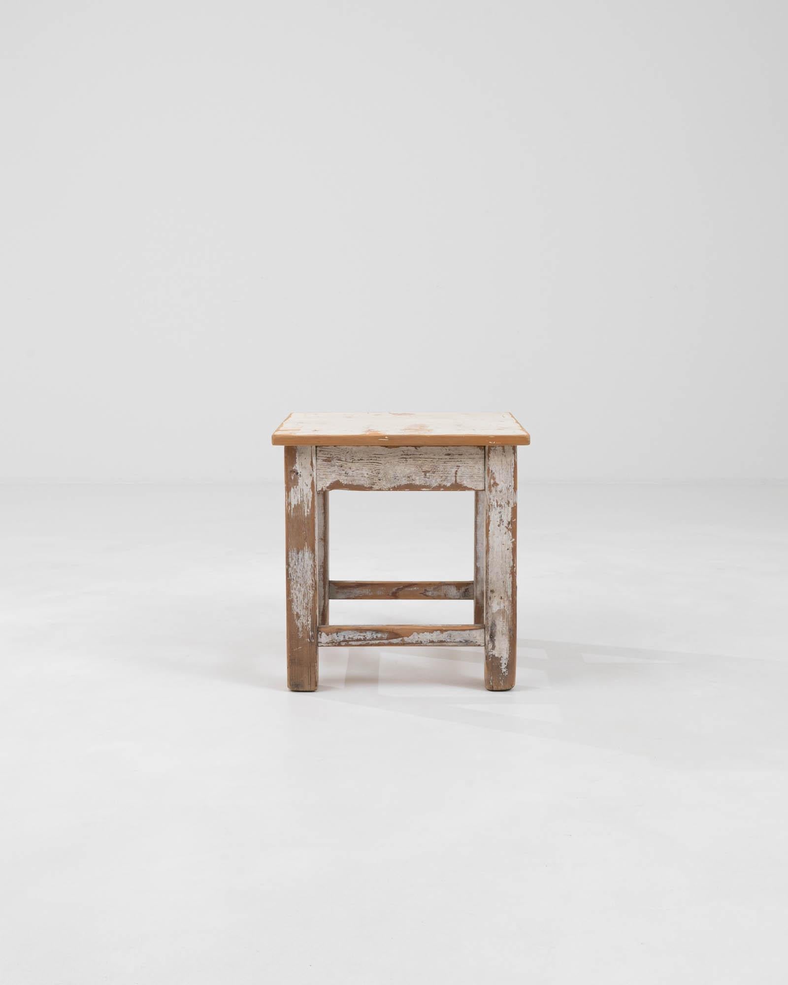 Présentant une pièce qui raconte une histoire avec chaque nœud et chaque grain, notre tabouret en bois patiné d'Europe centrale du début du 20e siècle dégage un charme rustique aussi durable que sa construction. Fabriqué à une époque où l'artisanat