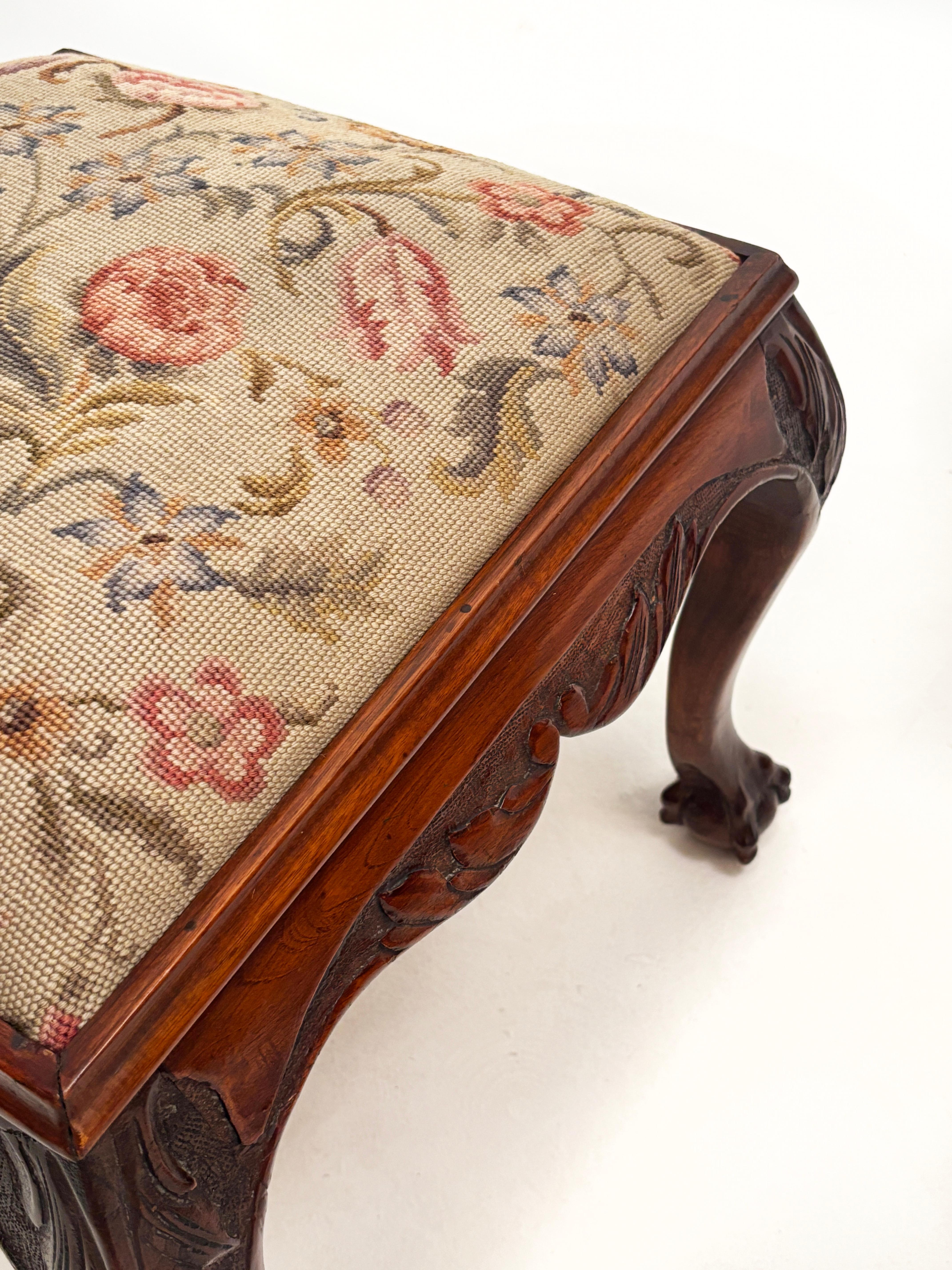 This beautiful cherry Chippendale, ball and claw stool is a bit more unique in size than most. Build in an almost square dimension, this wonderfully carved stool frame holds a meticulously done needlepoint cover. Marked on the backside by the