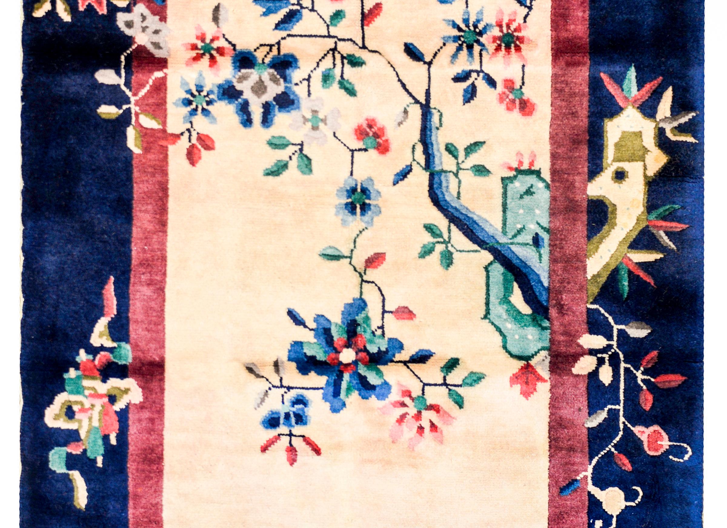A wonderful early 20th century Chinese Art Deco rug with a gorgeous champagne colored field surrounded by a thin cranberry stripe and a wide outer indigo stripe. Scholars ricks appear on the right side, with a flowering tree peony crossing the field.