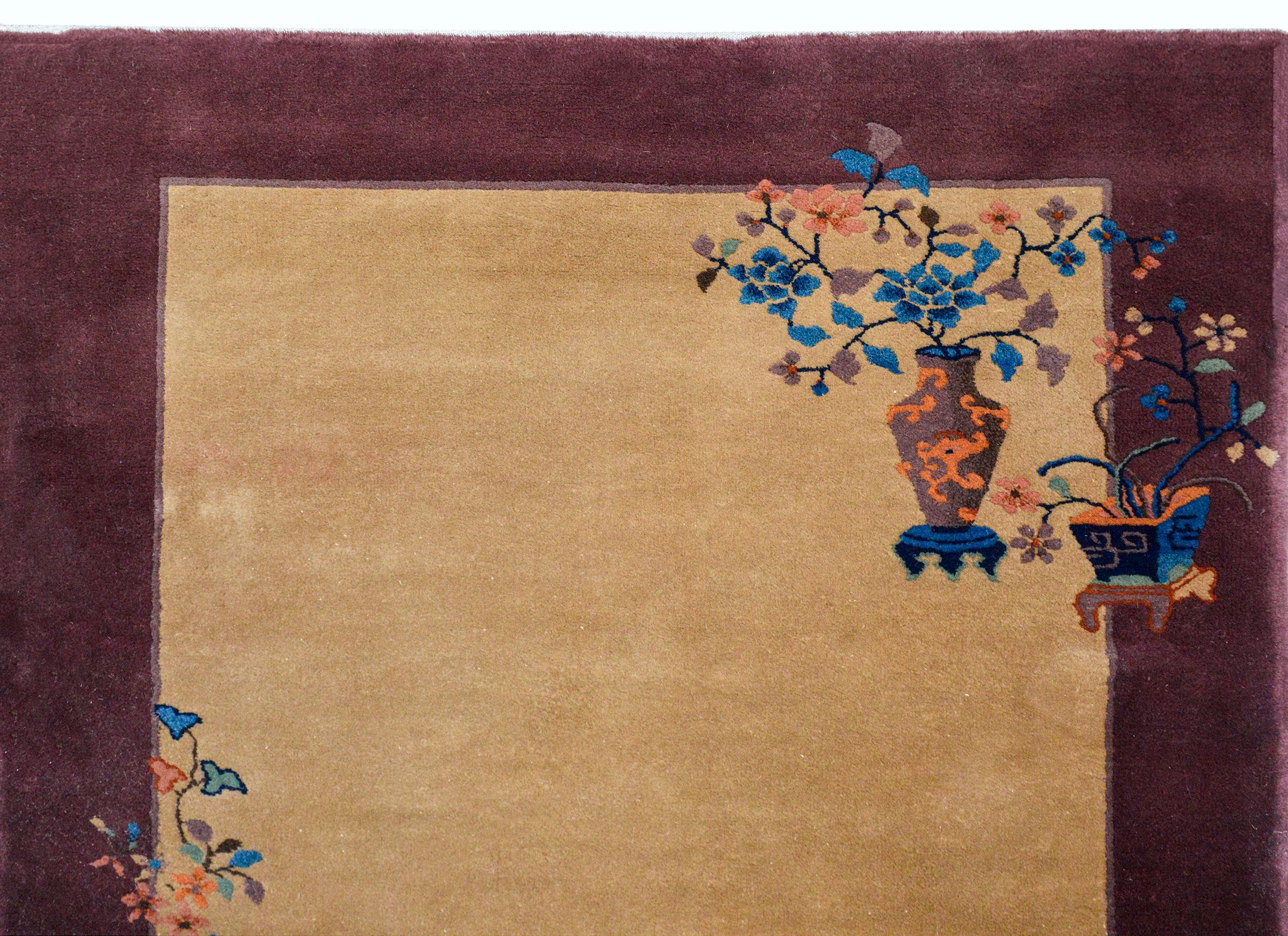 Ein wundervoller chinesischer Art-Déco-Teppich aus dem frühen 20. Jahrhundert mit einem schönen, einfarbig beigen Hintergrund und einer breiten violetten Bordüre, die mit vielfarbigen, verheißungsvollen Blumen wie Pfingstrosen und Kirschblüten sowie