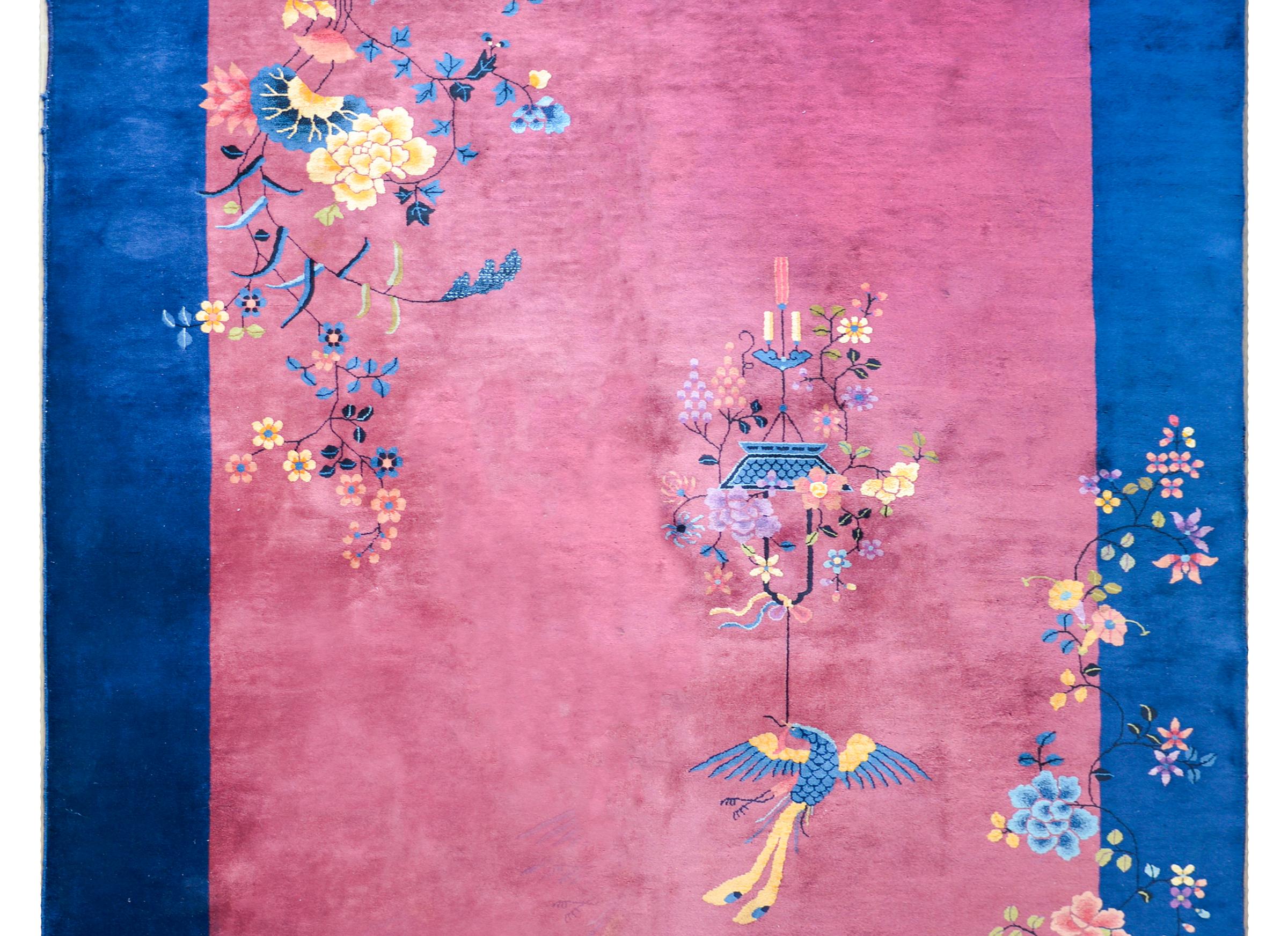 Ein wunderschöner chinesischer Art-Déco-Teppich aus dem frühen 20. Jahrhundert mit einem gedämpften Cranberry-Feld, das von einer breiten indigoblauen Bordüre umgeben ist und mit mehrfarbigen Pfingstrosen und Lotusblumen überlagert wird.