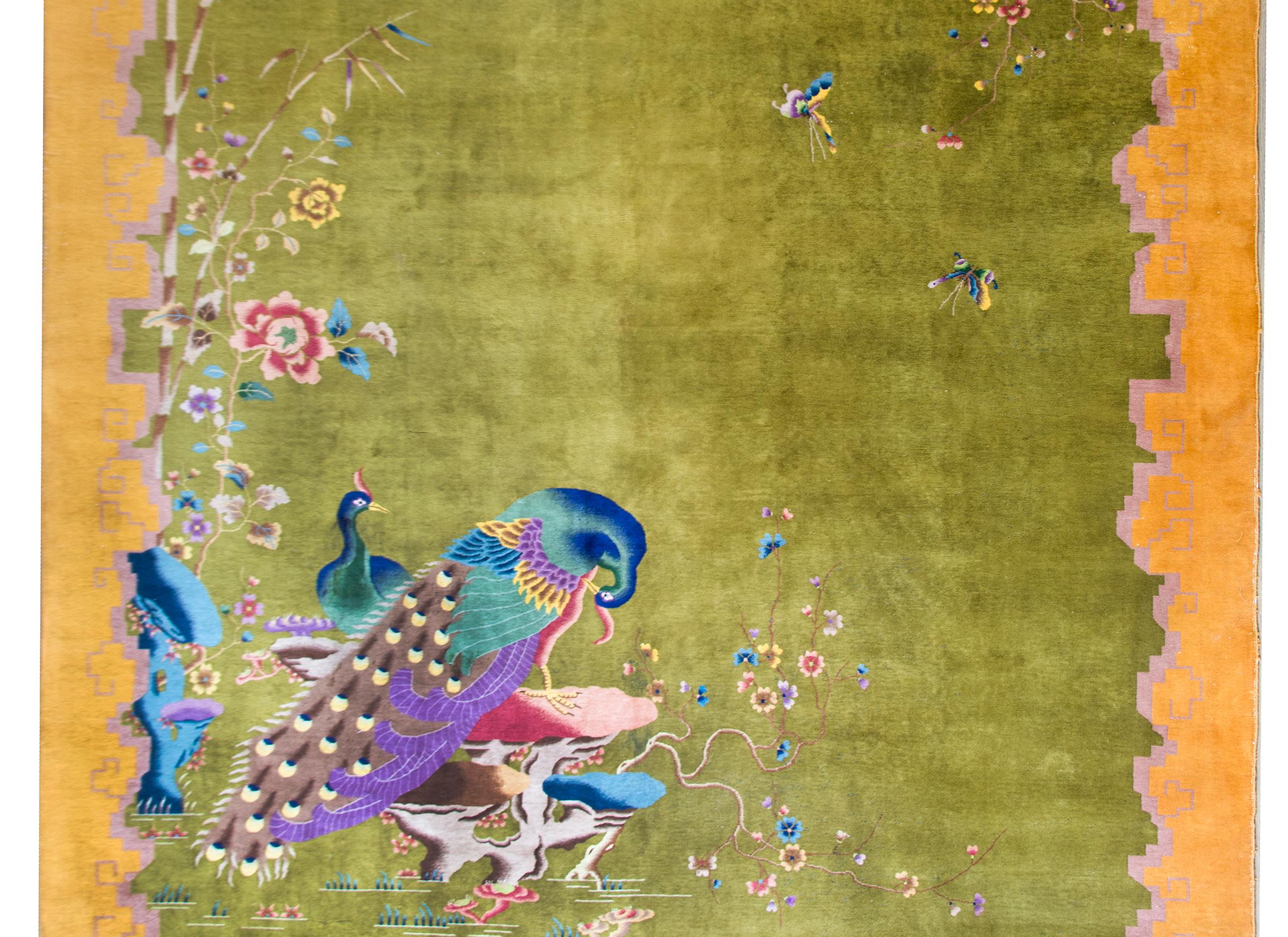 Ein bemerkenswerter chinesischer Art-Déco-Teppich aus dem frühen 20. Jahrhundert mit einem leuchtend chartreusegrünen Feld, das von einer breiten gold- und lavendelfarbenen, stilisierten Wolkenmotiv-Bordüre umgeben ist. Zwei große Pfaue leben in