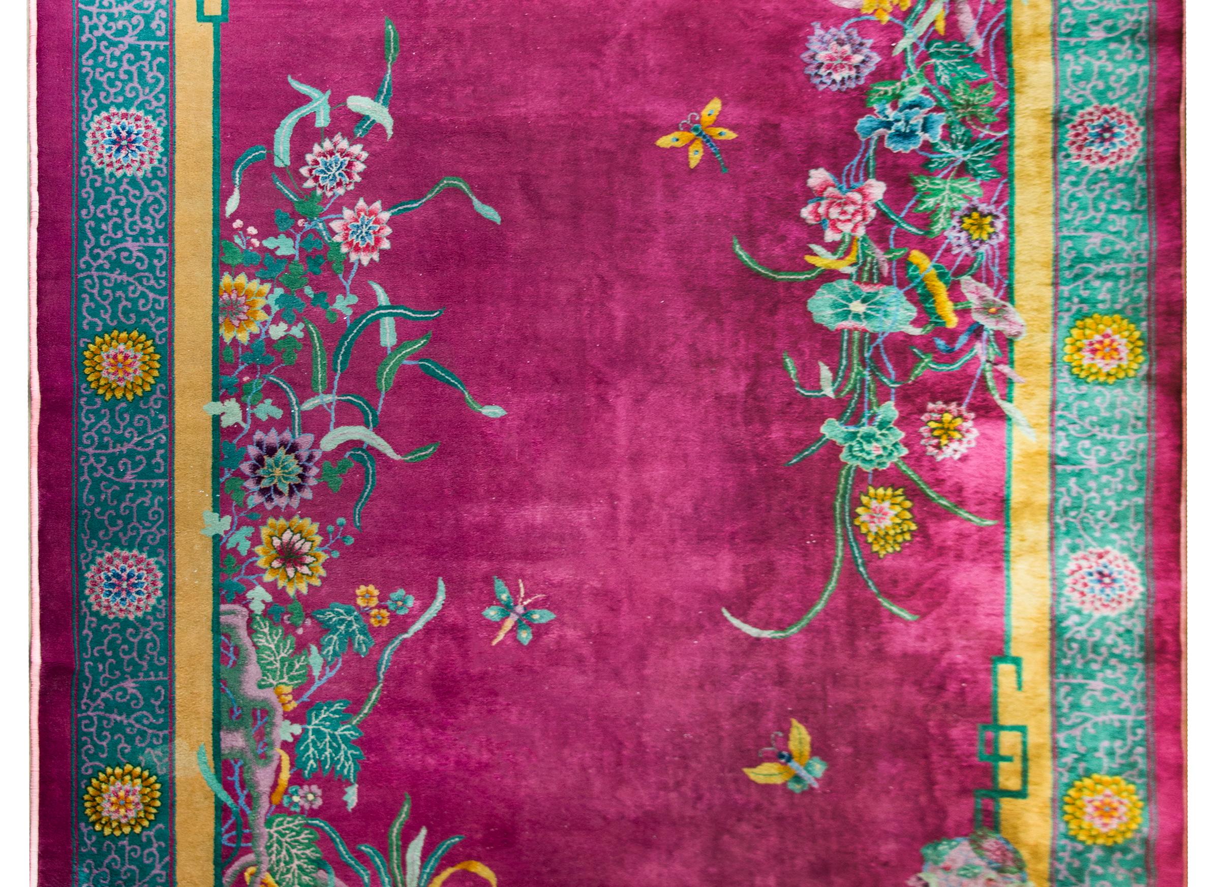 A beautiful early 20th century Chinese Art Deco rug with a brilliant fuchsia field surrounded by a border with large-scale chrystanthemum flowers amidst a tightly woven scrolling vine patterned field. More auspicious flowers overlay the field and