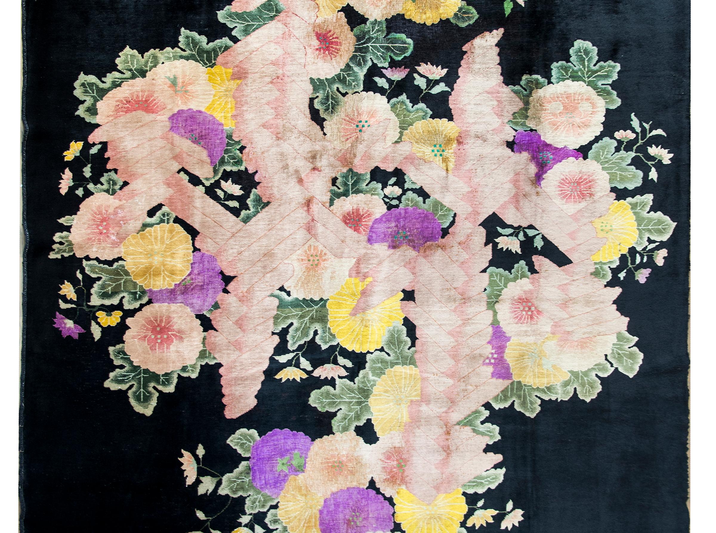 A chic and sophisticated early 20th century Chinese Art Deco rug with a black background with the most incredible large central peony and chrysanthemum cluster woven in gold, pink, and violet.