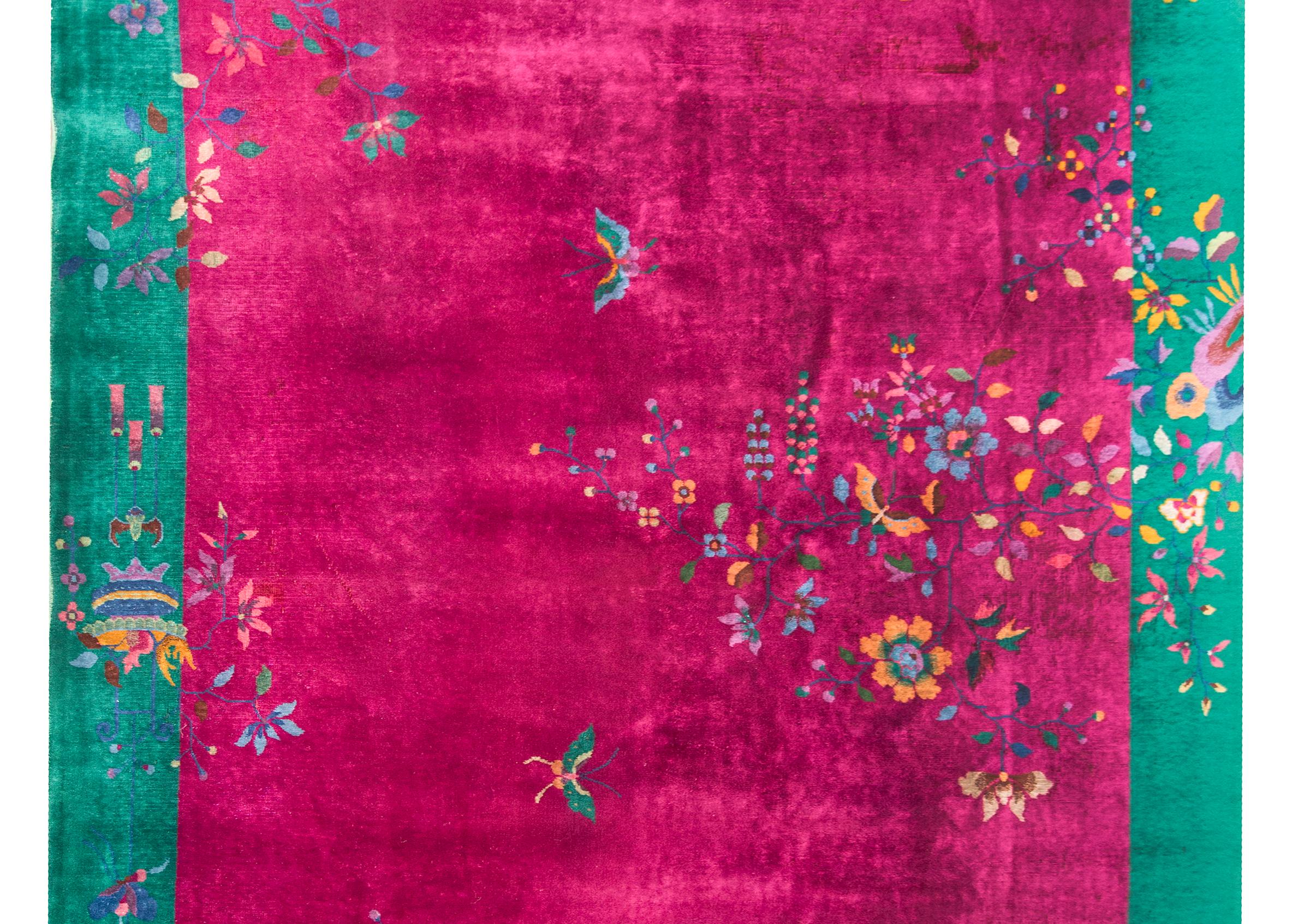 Magnifique tapis chinois Art déco du début du XXe siècle, dont le fond fuchsia est recouvert d'une myriade de pivoines et de fleurs de bon augure, et de papillons tissés dans des tons roses, indigos, dorés et verts brillants, le tout entouré d'une