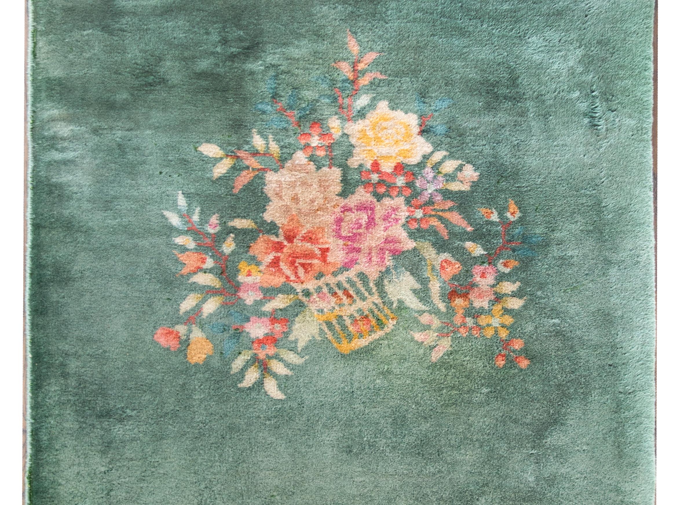 A beautiful early 20th century Chinese Art Deco rug with mint green field with a basket filled with multi-colored peonies in the center.