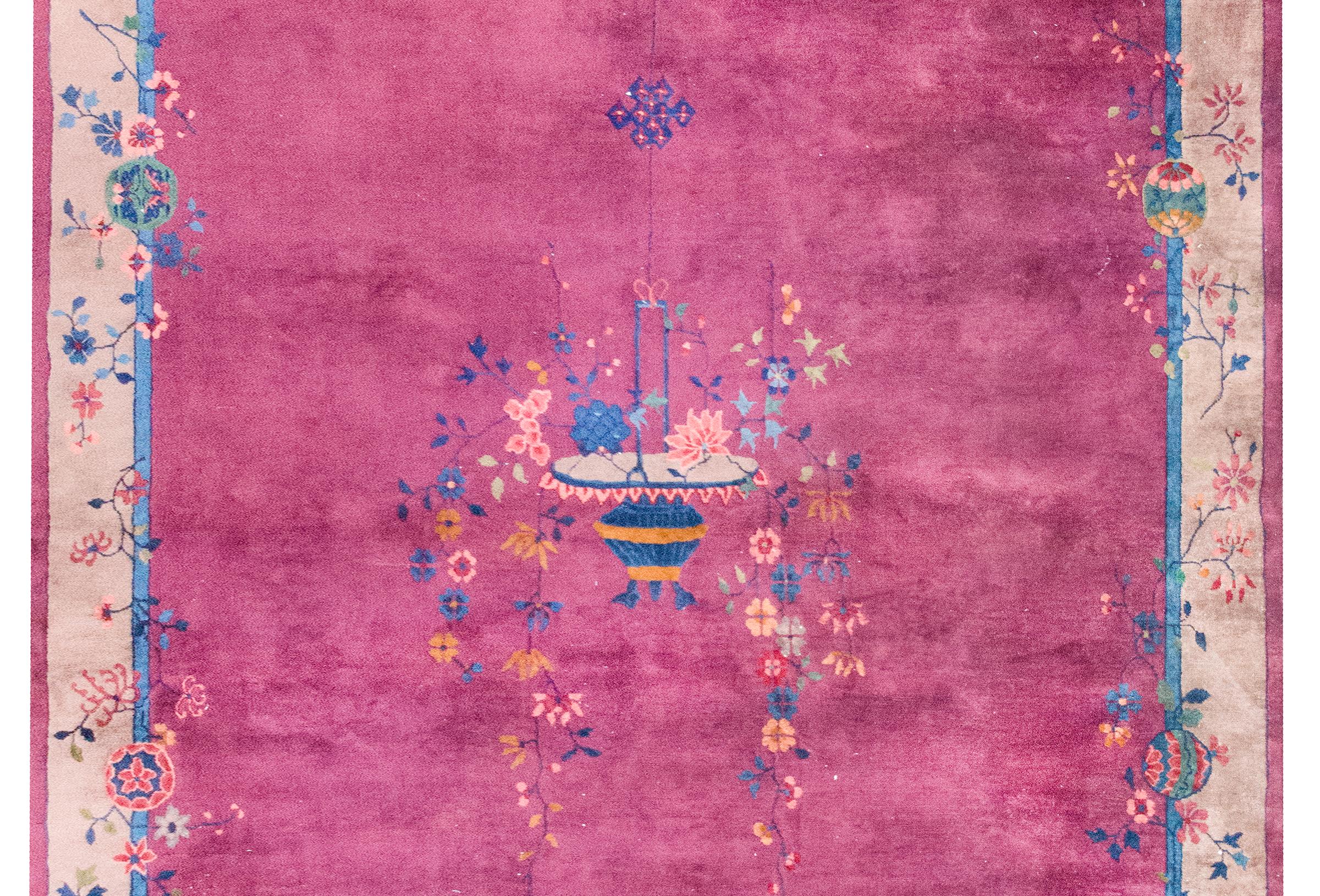 Tapis chinois Art déco du début du XXe siècle, avec un champ central violet entouré d'une large bordure brune flanquée d'une fine bordure intérieure indigo et d'une fine bordure extérieure violette, et avec un grand panier de fleurs à la main avec