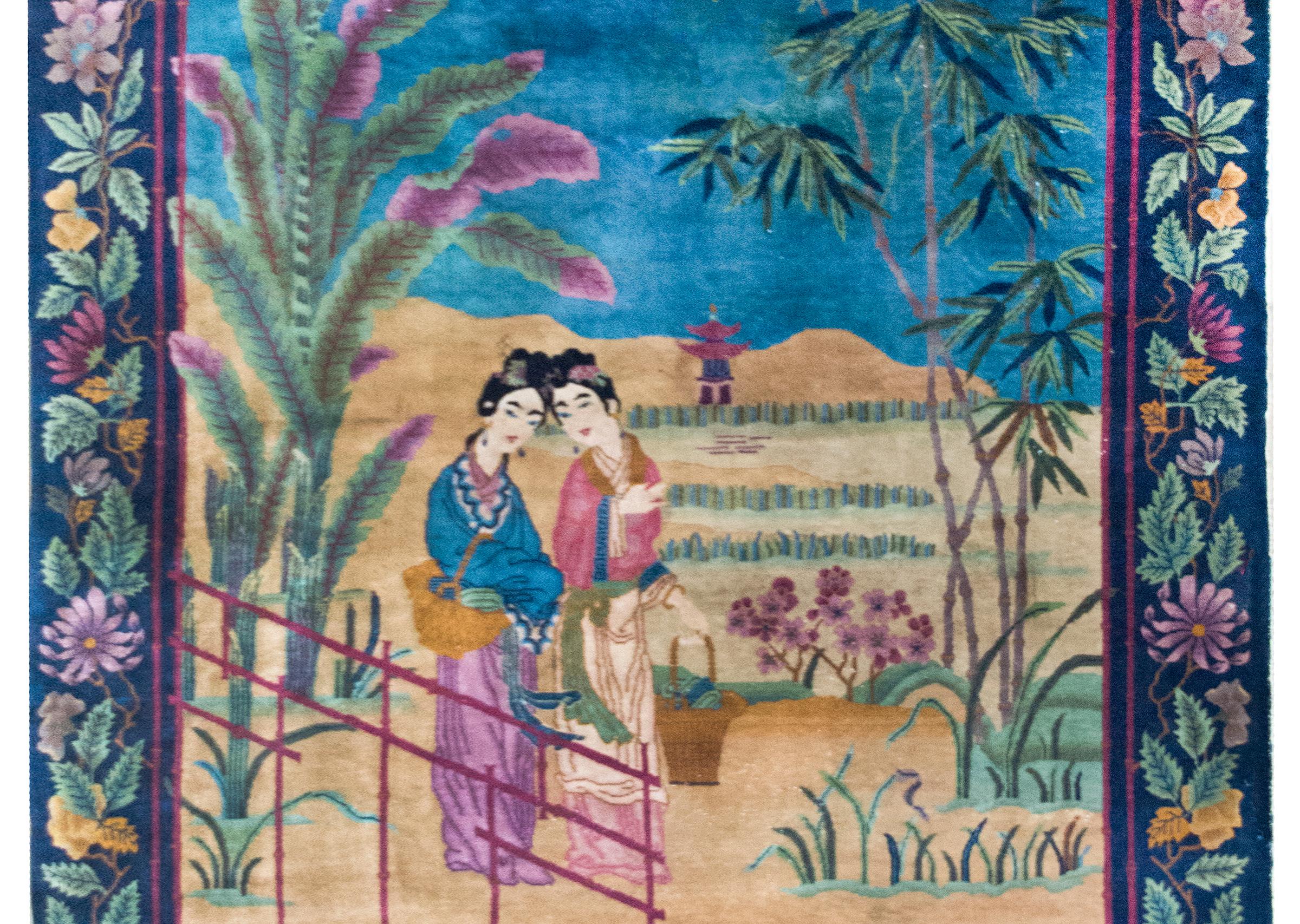 This early 20th-century Chinese Art Deco rug is a vibrant tableau of leisure, abundance, and artistic sophistication. Two elegant women walk gracefully along the edge of a lush garden, each carrying a basket brimming with vegetables. A large palm