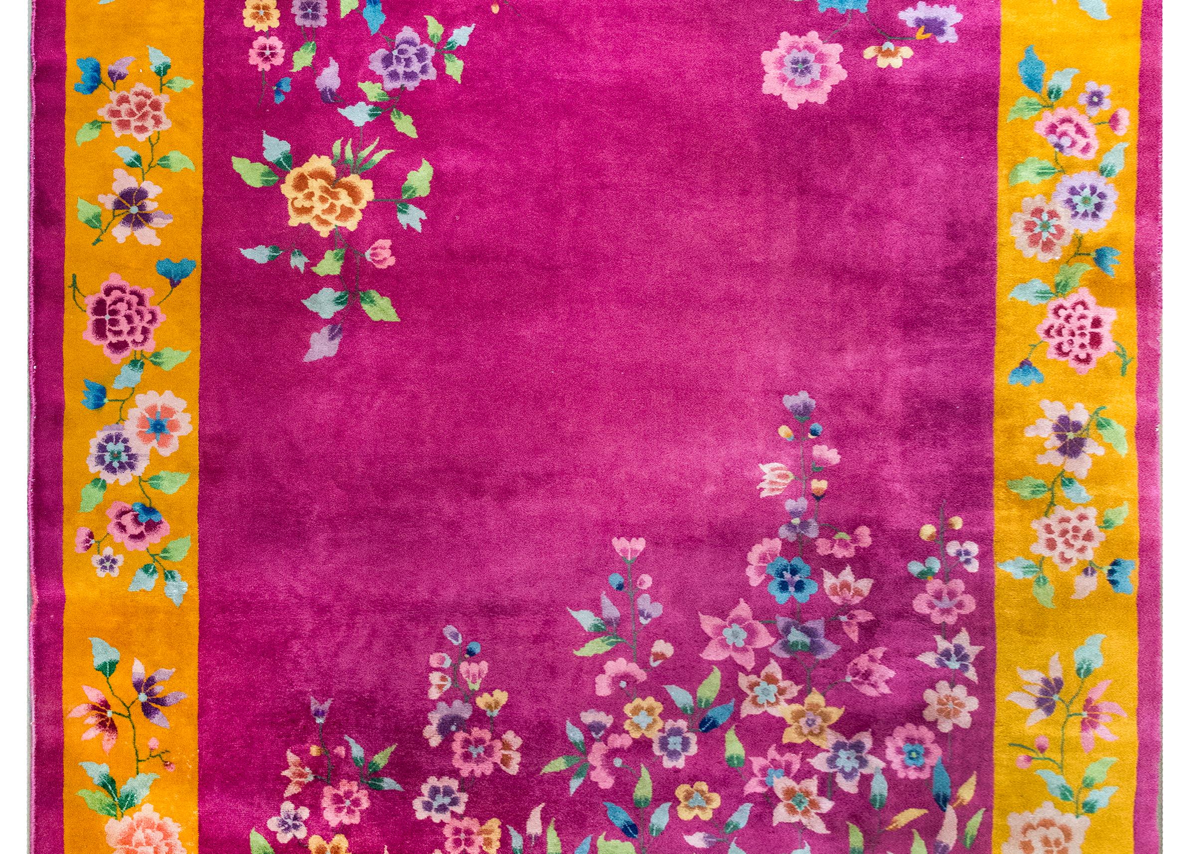 This early 20th-century Chinese Art Deco rug is all about color and scale. The field is a deep, saturated fuchsia—unusual and undeniably striking—surrounded by a wide golden border and a thin fuchsia band around the edge that ties it all together.