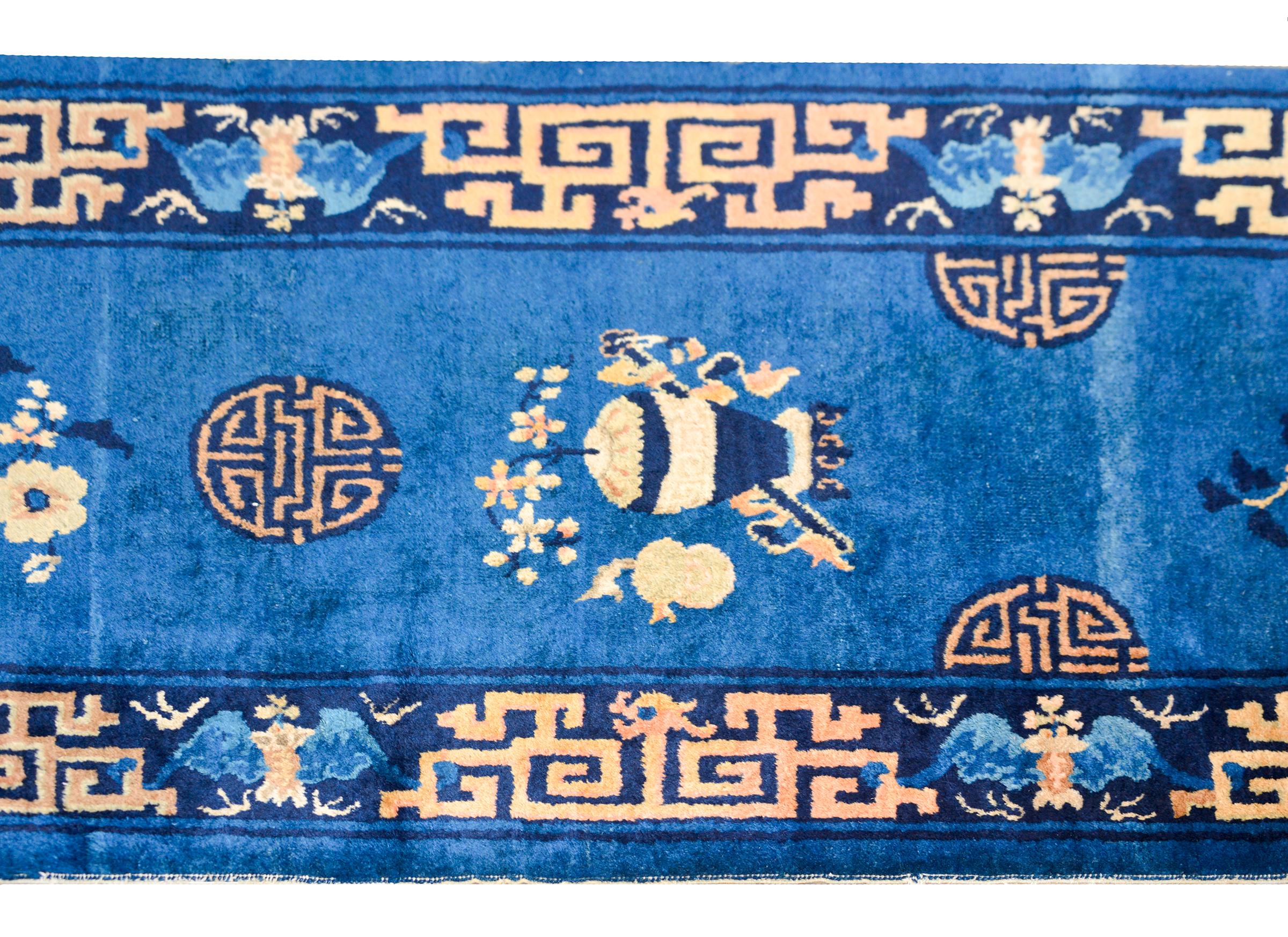 A wonderful early 20th century Chinese Art Deco runner with alternating auspicious floral and Shou character medallions set against an indigo background, and surrounded by a beautiful bold border with bats and scrolling dragons. In China, the Shou