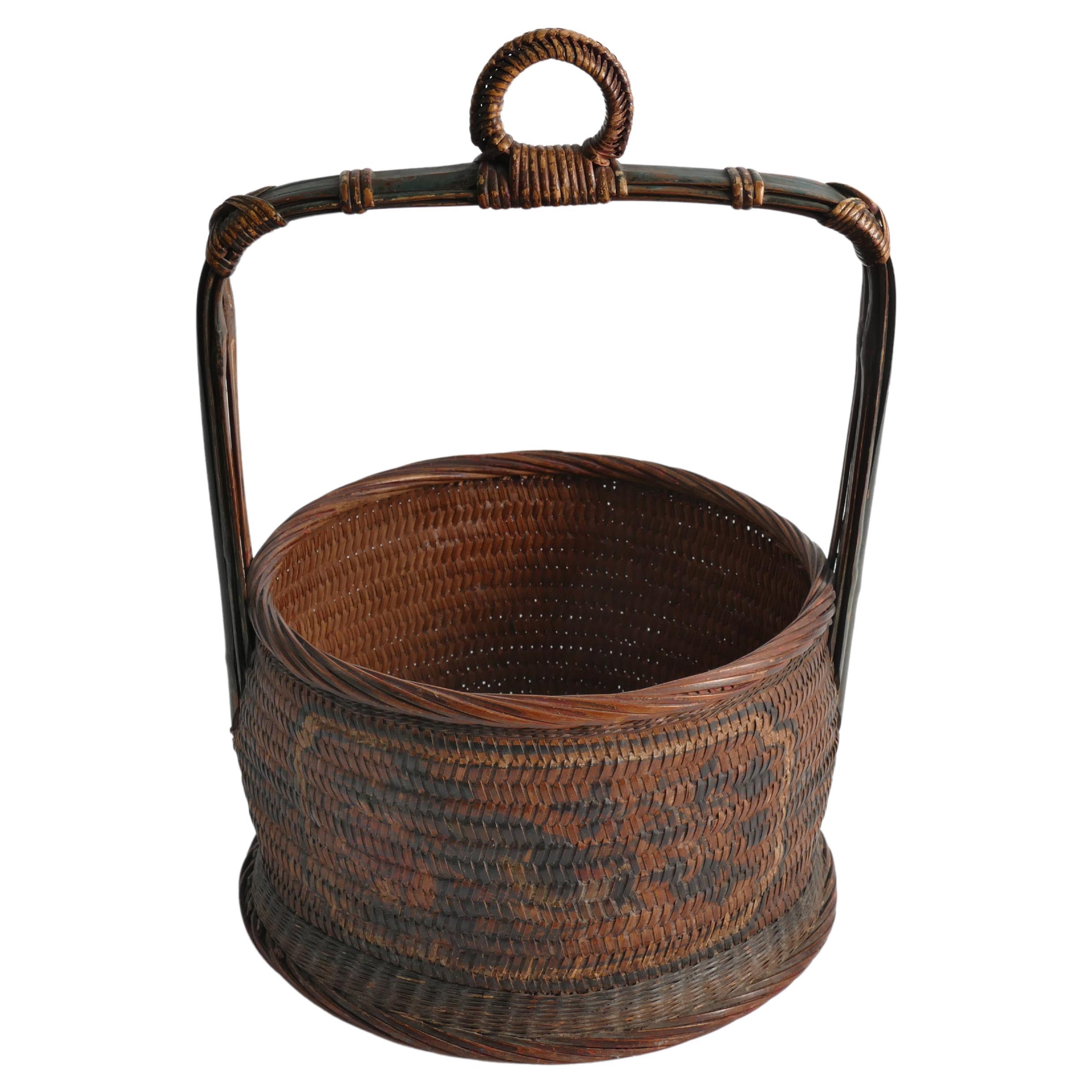 This early 20th-century bentwood bamboo/rattan/wicker Chinese wedding basket with polychrome paint is marvelously beautiful. The basket It has very beautiful and intricate weaving details and showcases a rounded body and a squared, fixed handle at