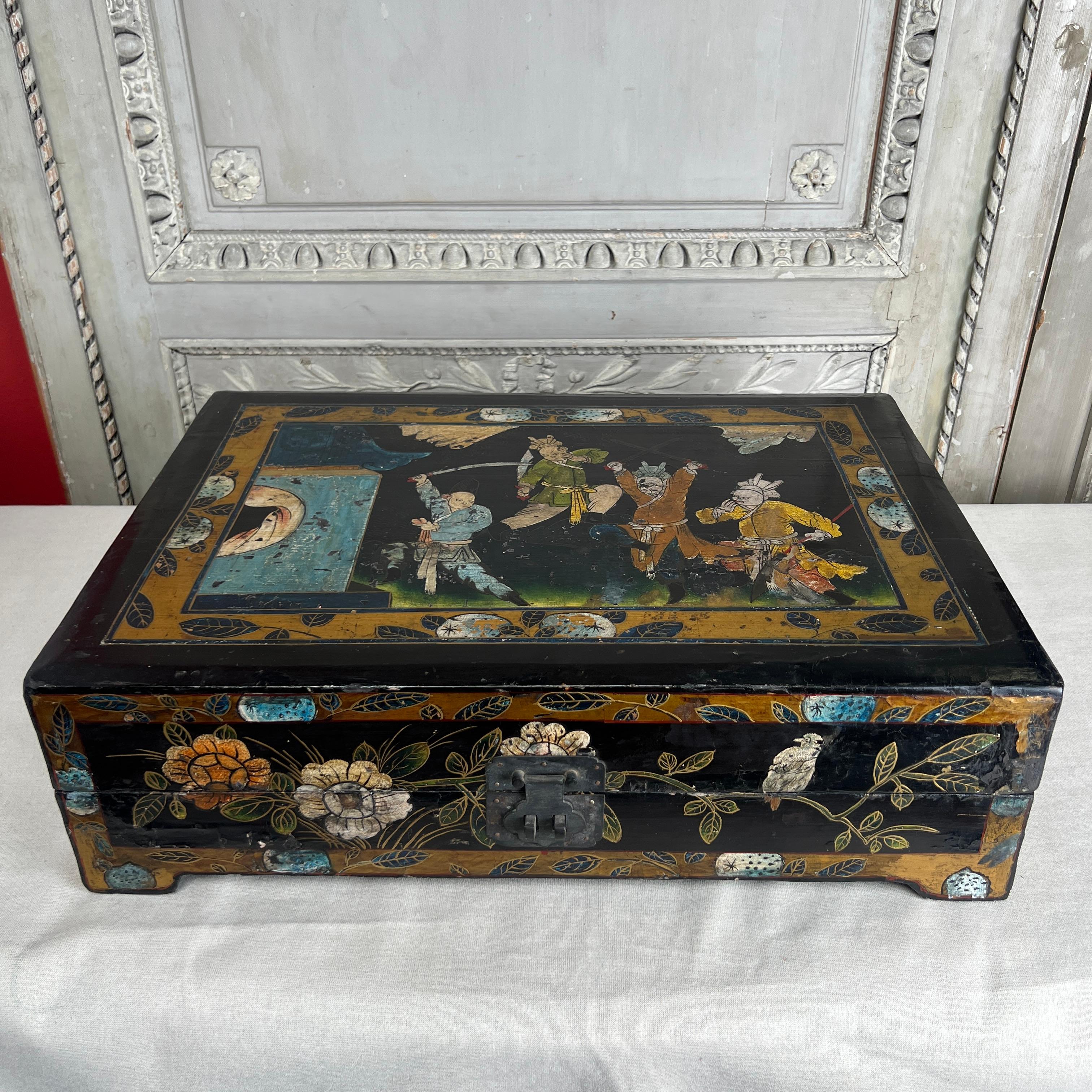 A large early 20th century Chinese lacquered box with gilt and polychrome decoration having warriors and flowers. 
This highly decorative box is large and easily used, it would be ideal to use for remote controls on a coffee table.