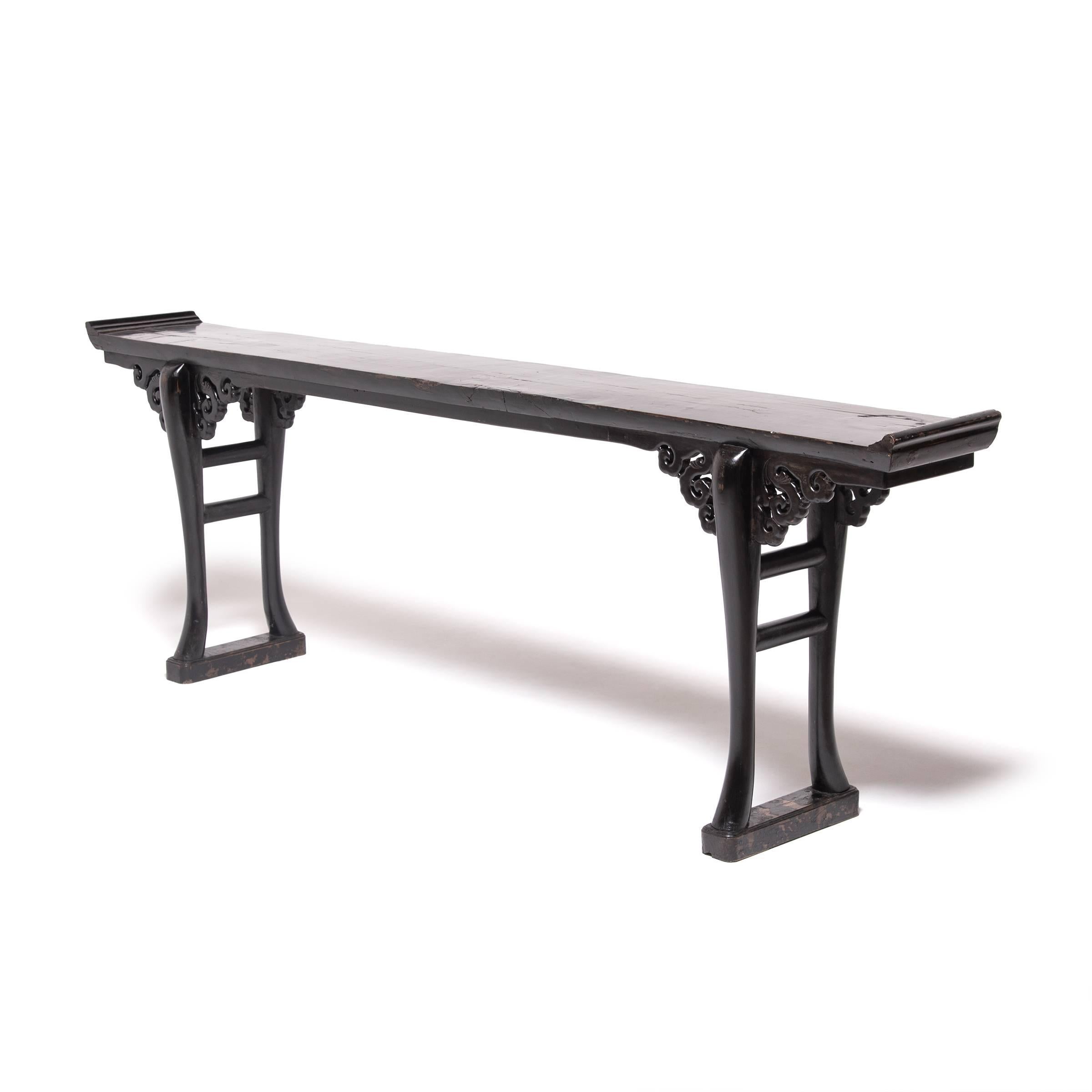 Gathered from the forests of northern China, elmwood provided the raw material with which highly skilled artisans created this elegant altar table. Eight dragons, symbolizing strength, and intricate cloud-like scrollwork skillfully carved on the