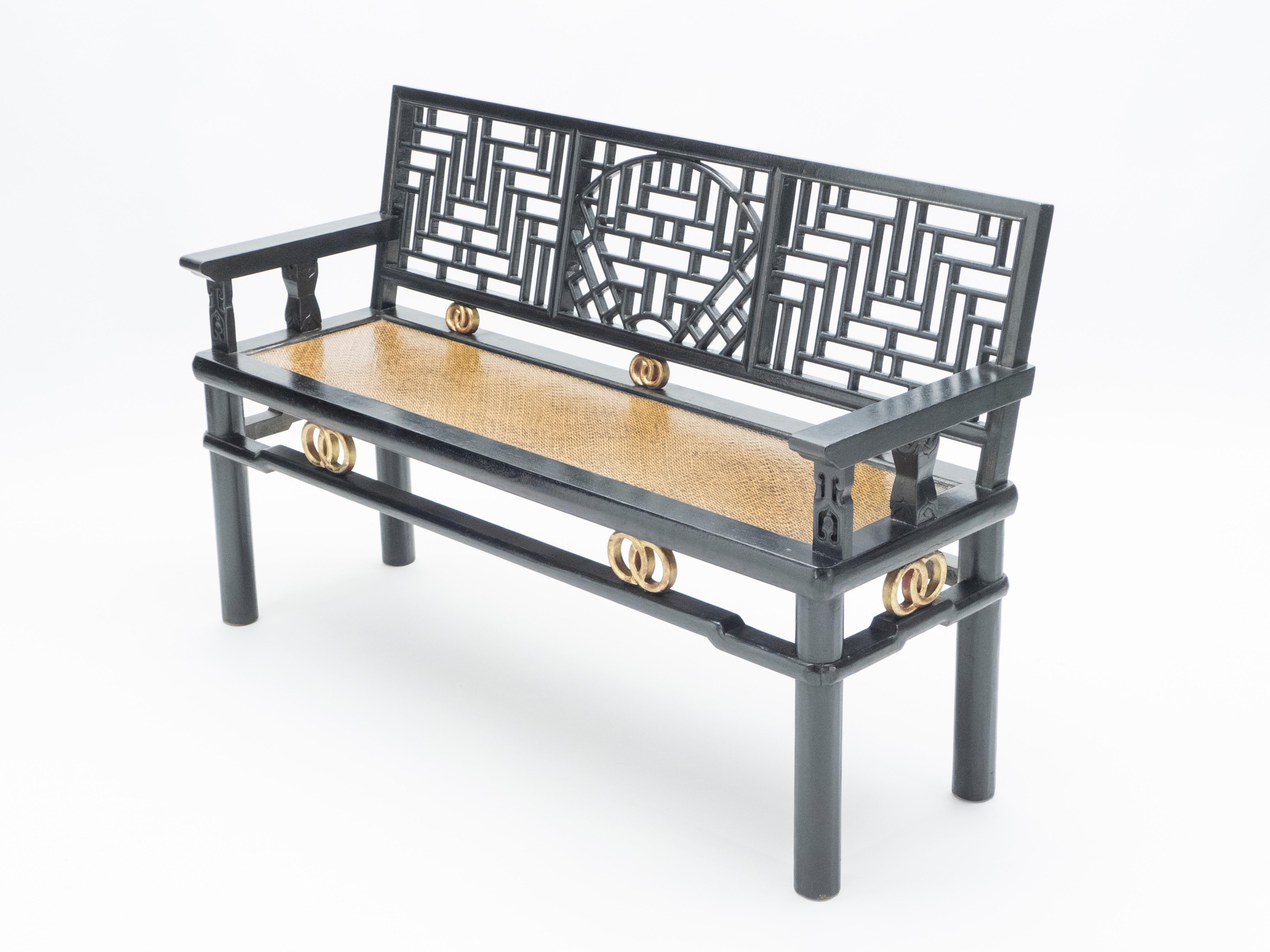 Beautiful early 20th century Chinese bench in black lacquered wood with golden details and woven seat. Geometrical seat back, round legs and very nice patina for this bench gives it a striking presence that works seamlessly into any interior, but