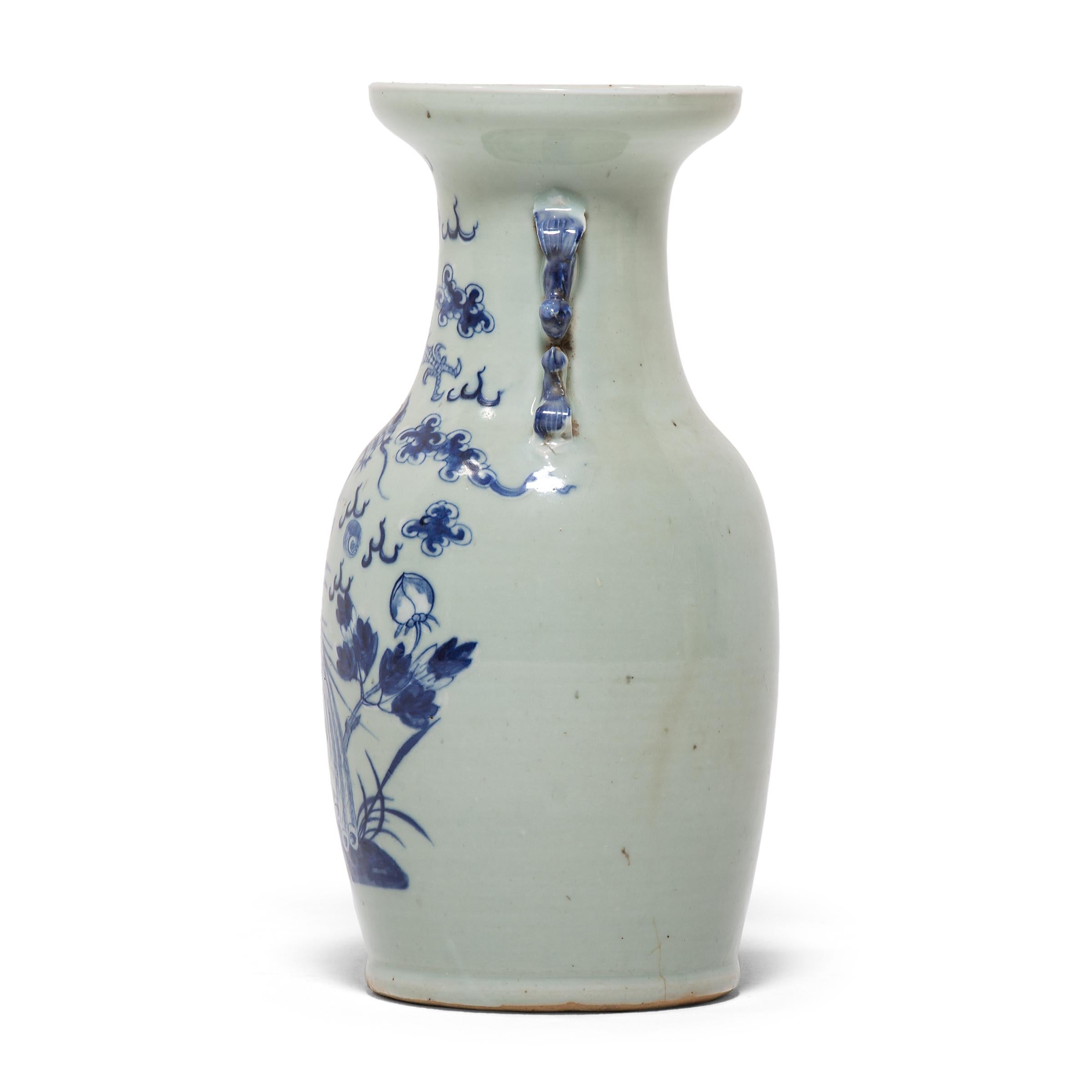 This exquisite 19th century porcelain vase has a gently tapered body and a wide, flared lip, flanked by two molded scroll handles. Painted with expressive brushwork, the vase depicts a serpentine dragon soaring through clouds and a regal phoenix