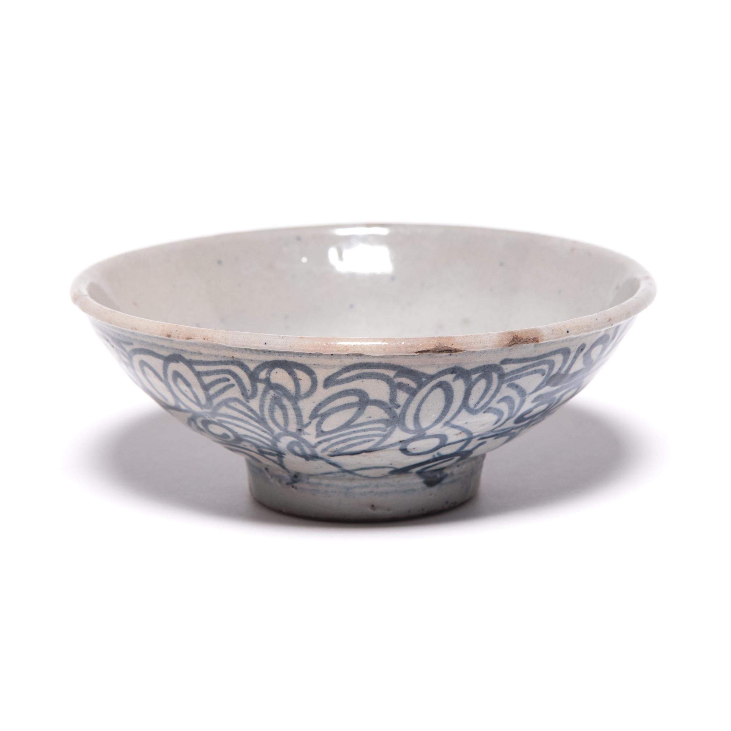 This late 19th century footed bowl would have been offered by Chinese traders traveling along the silk road in exchange for spices or gems. The Chinese artisans who hand painted it with scrolls, loops, and crossed lines thought the meandering