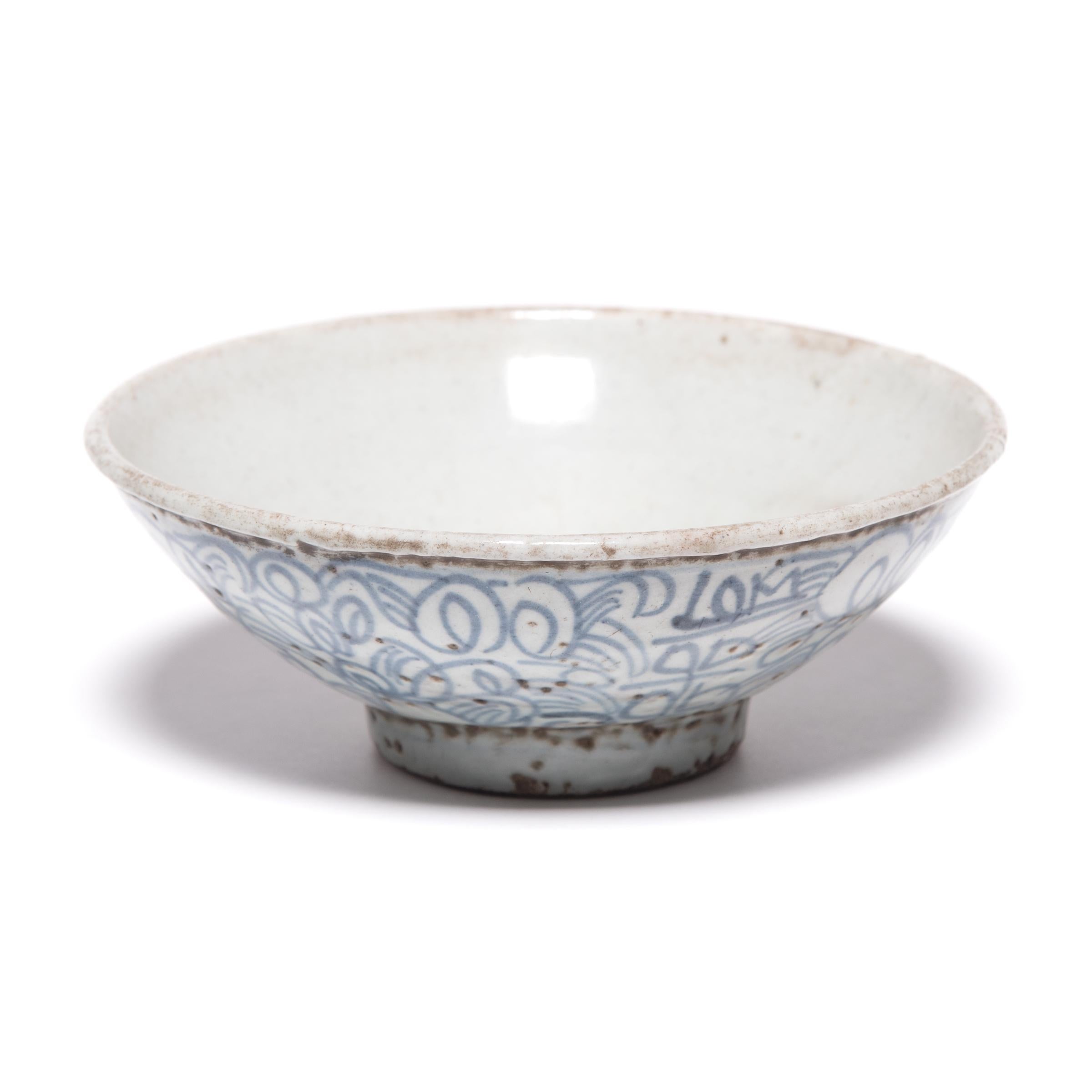 This late 19th century footed bowl would have been offered by Chinese traders traveling along the Silk Road in exchange for spices or gems. The Chinese artisans who hand-painted it with scrolls, loops, and crossed lines thought the meandering