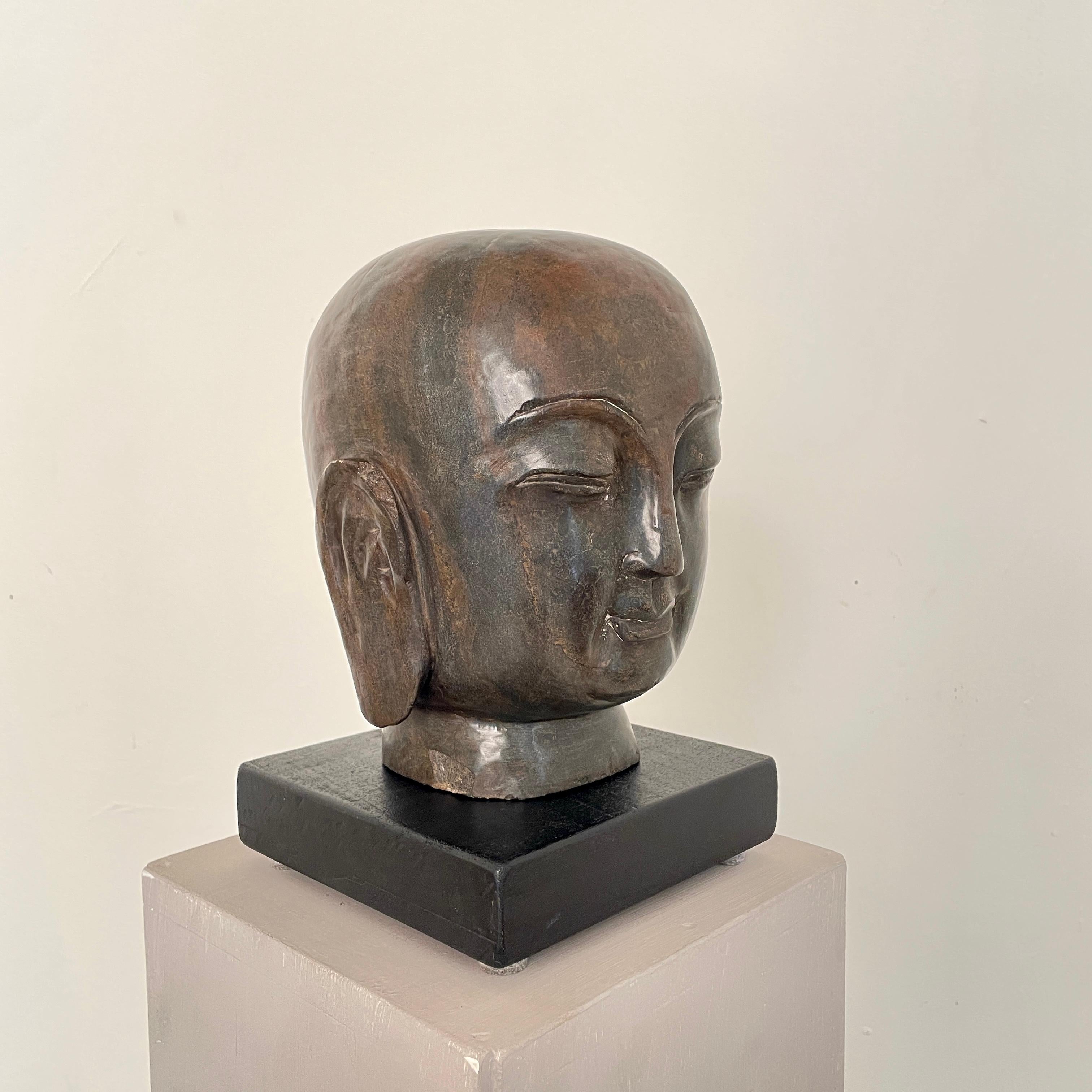 Beautiful Early 20th Century Chinese Buddha Stone Head made around 1920.
This chinese carved head of Buddha was sensitively molded off limestone. The head looks out from heavily almond shaped eyes, under high arched browns, his full lips pursed in a
