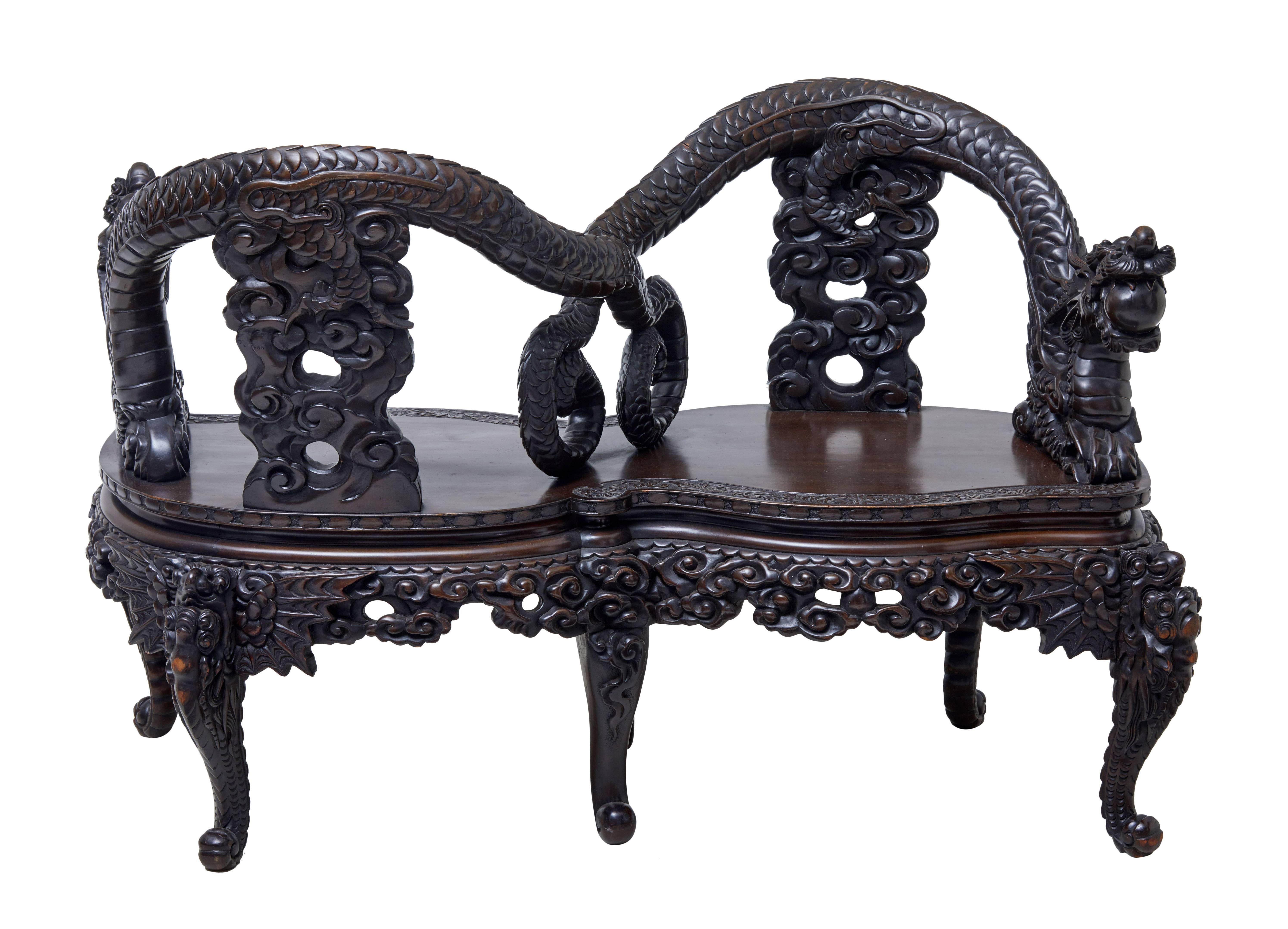 Decorative Chinese export profusely carved loveseat, circa 1900.

Made from hard wood similar to elm.

Heavily carved dragons, with the tails forming the back rest and overlapping arms.

Standing on six scrolling legs.

Measures: Seat height