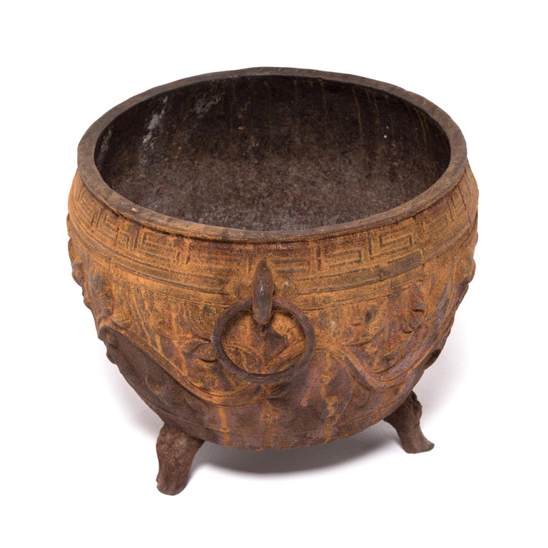 China was the earliest known civilization create works with cast iron, first appearing thousands of years ago during the illustrious Zhou dynasty. Textured with lotus blossoms in high relief and balanced on tripod feet, this contemporary urn
