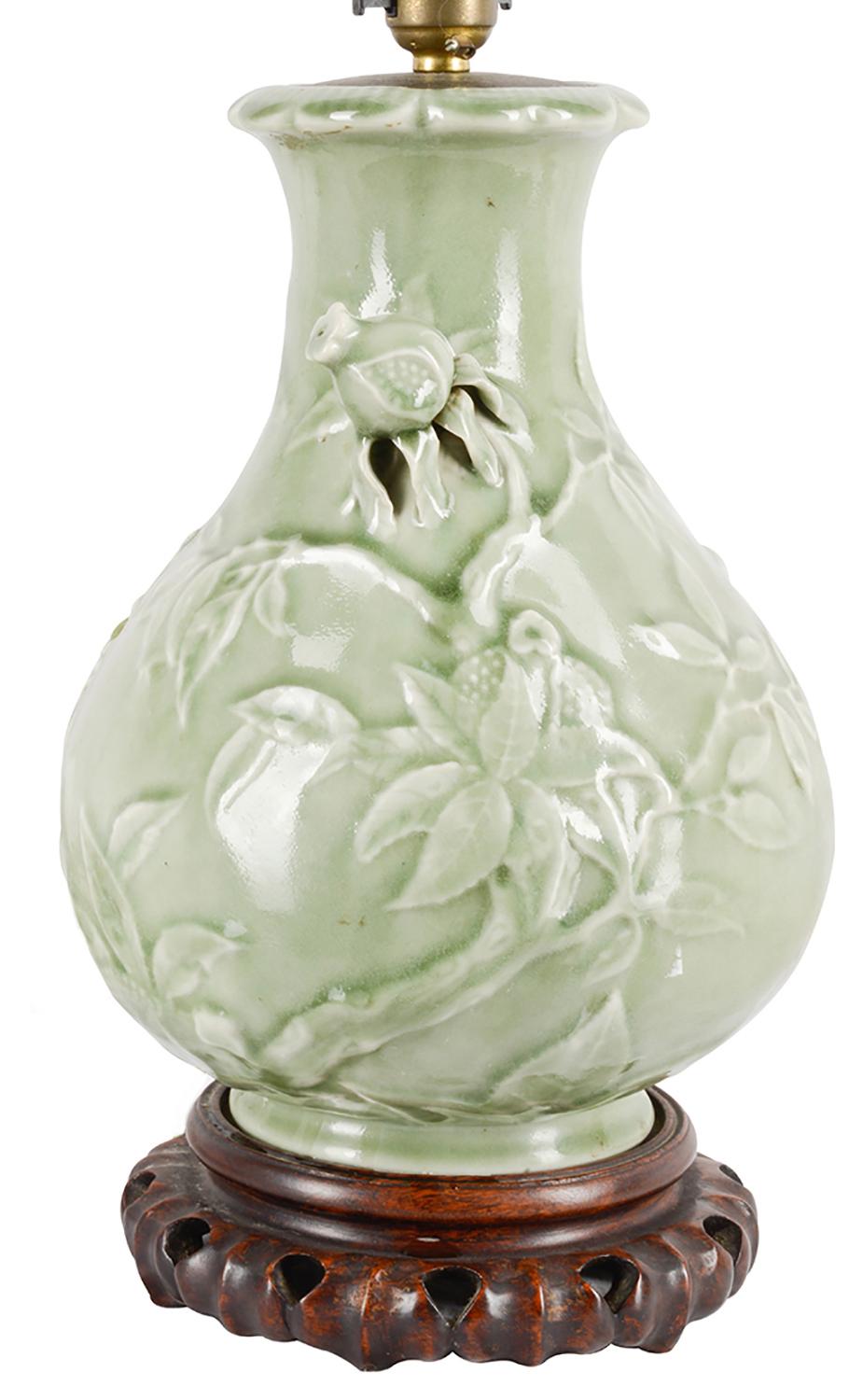 A good quality early 20th century Chinese celadon vase, with wonderful raised and pierced decoration of exotic flowers and leaves. Raised on a carved hardwood stand. Measures: 34cm (13.5
