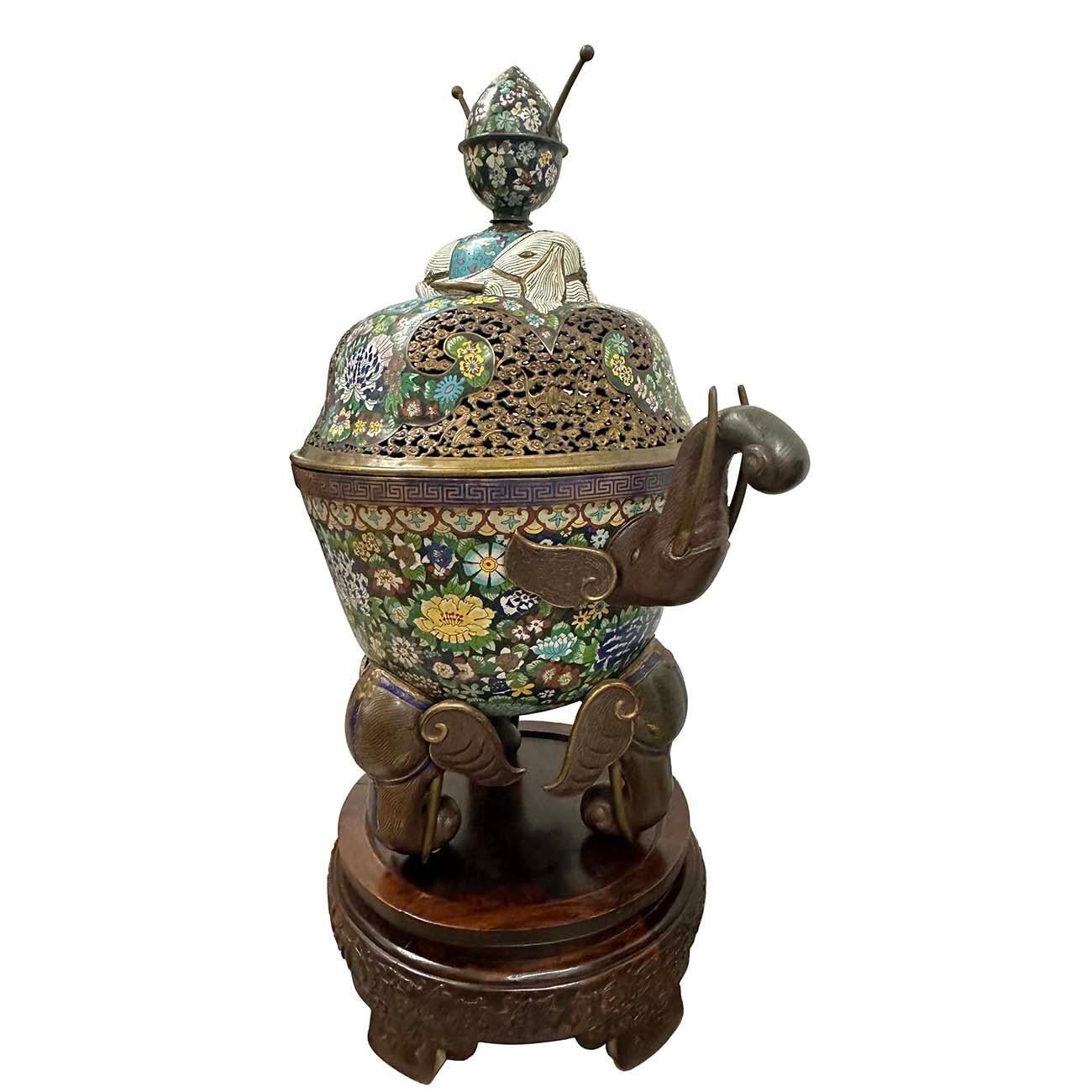 Museum Quality Chinese Champleve Cloisonné Incense burner of monumental size standing on a wonderful carved hardwood base. Gilt brass with enamel decoration, reclining elephant with carpet draped over and hollow carving of clouds and bats on the top