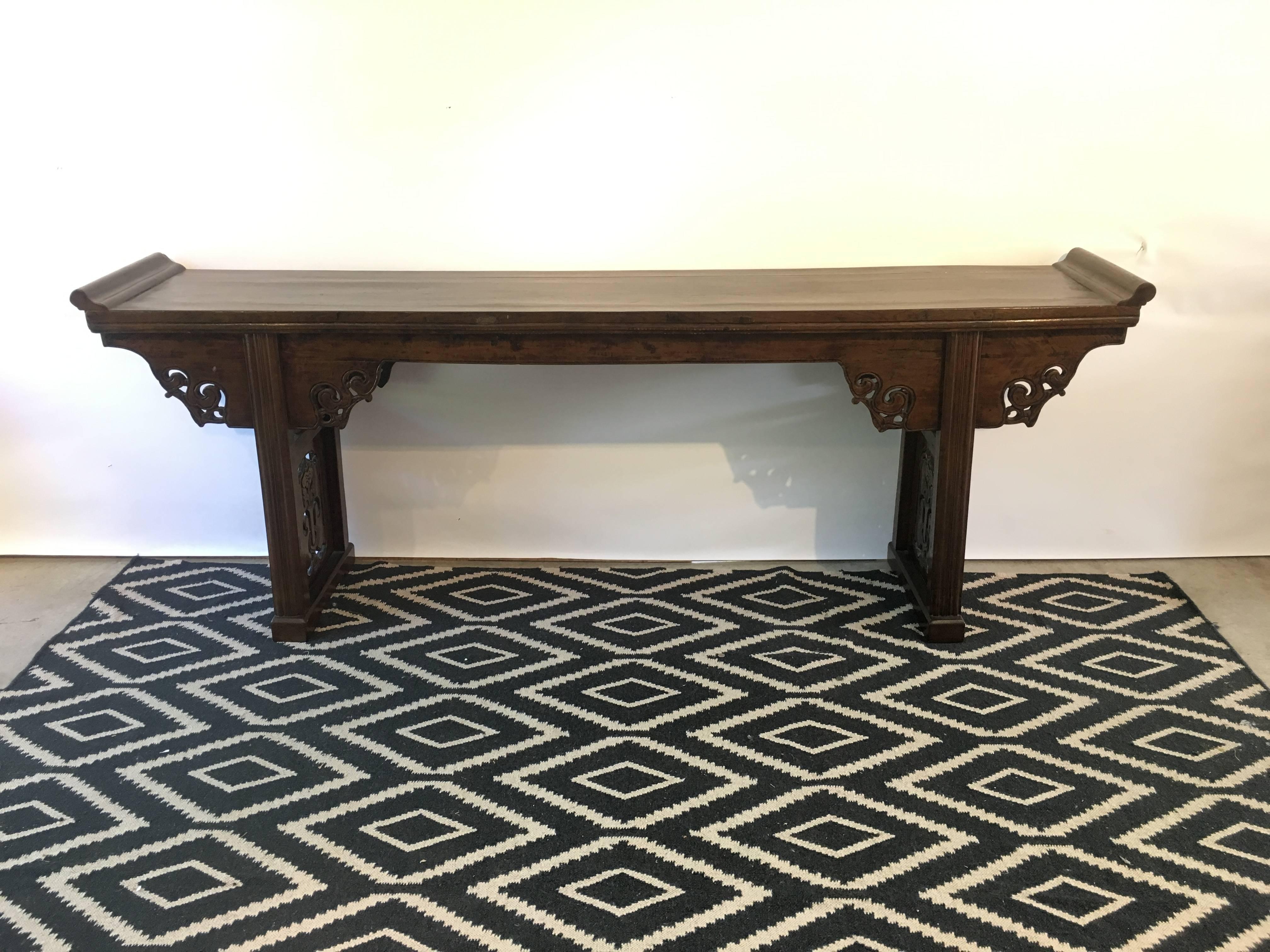 An antique classical Chinese elmwood altar table, late Qing Dynasty, circa 1900, China.
The elegant altar table crafted in the traditional manner with joined elmwood and aprons featuring carved and pierced spandrels with an abstracted qilong dragon