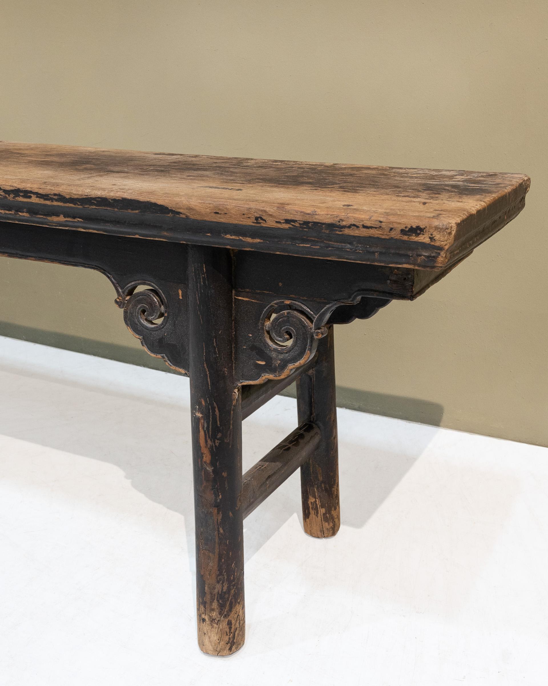 A recessed leg long bench with carved cloud spandrels, from Shanxi province. Its round legs are slightly tapered and they have a diameter of approx. 5.4cm. There are double stretchers on the sides and the seat top is made of a single plank of solid