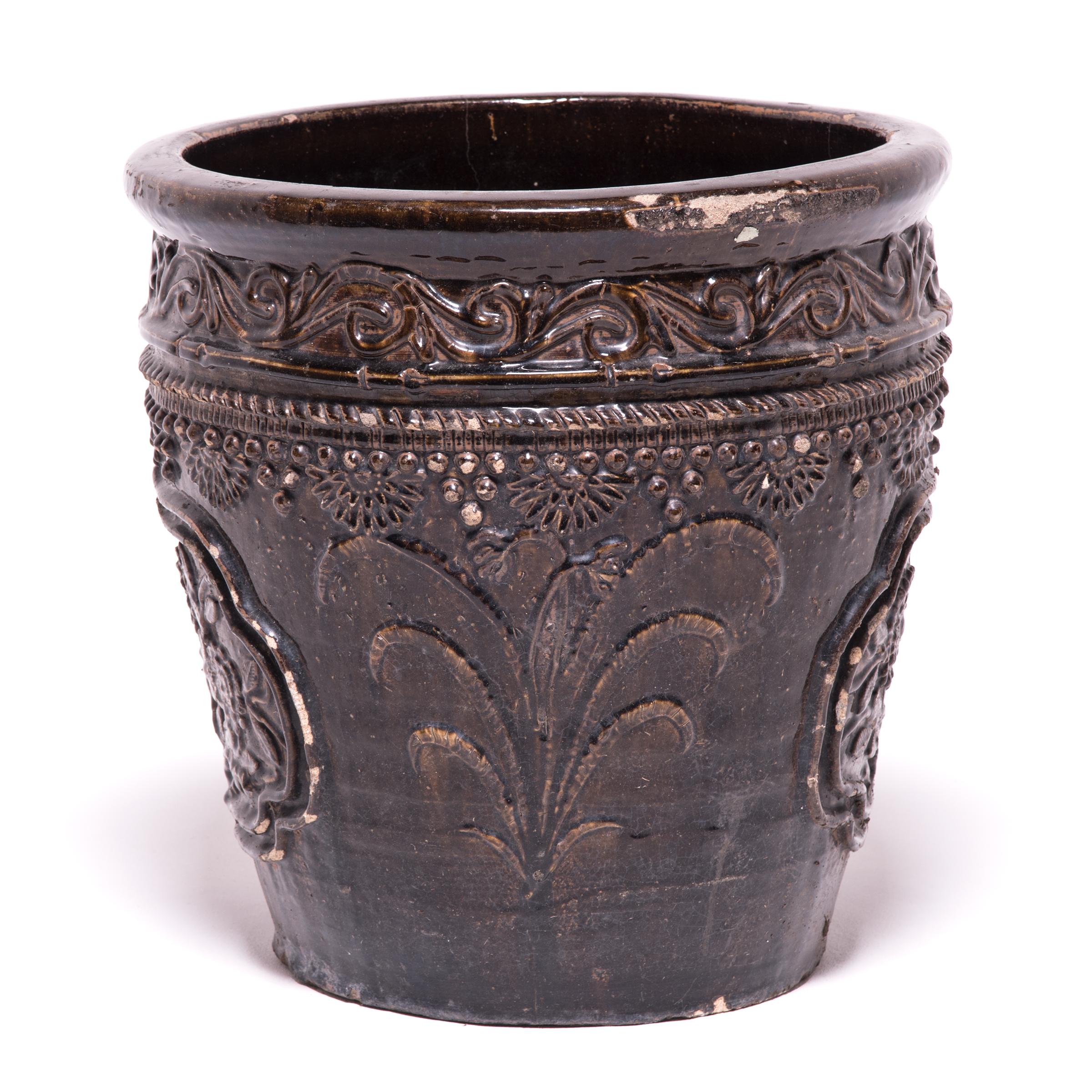 Rendered in high relief, this ceramic jar’s dimensional bands, hobnail motifs and flower-filled medallions add visual interest and texture to its rich brown glaze. Decorated with chrysanthemums, a symbol of longevity, the jar embodies this promise,