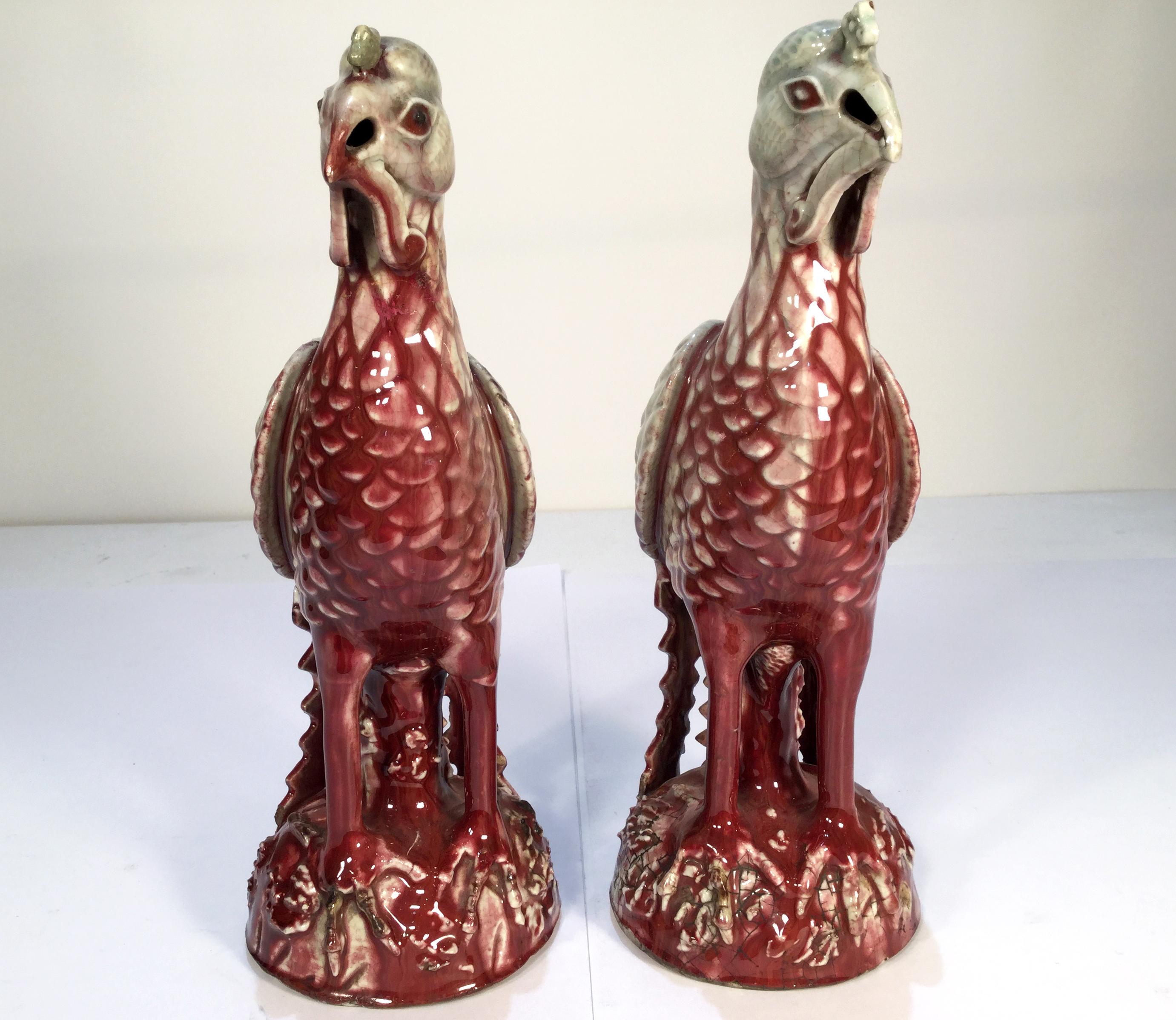 20th century Chinese Export pair of Sang de Boeuf ceramic Ho Ho Birds with a wonderful celadon glaze. This pair of bird sculptures have a strong Classic design in a Art Deco manner.