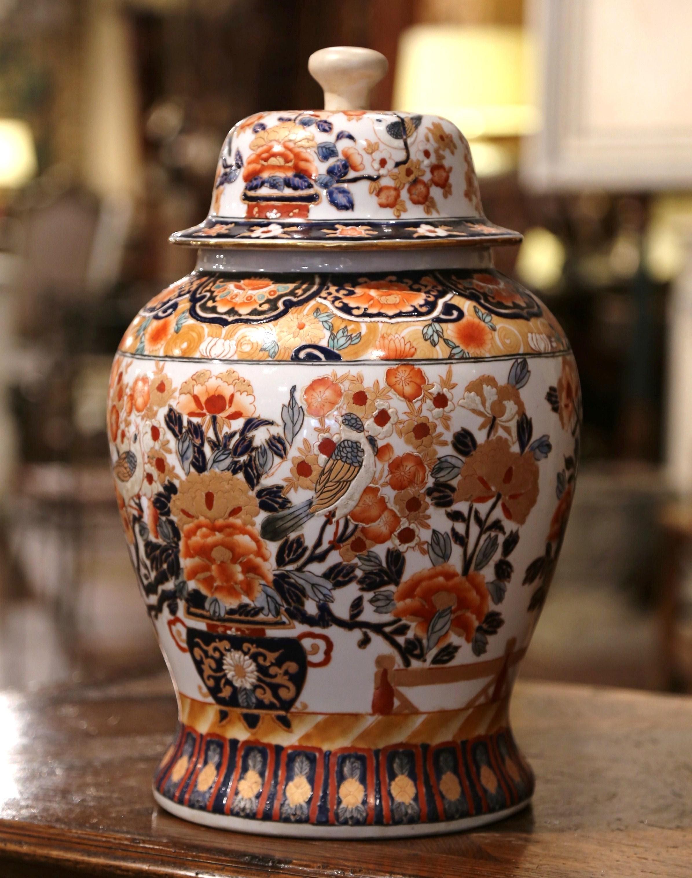Decorate a console or mantel (fireplace) with this important colorful antique porcelain ginger jar. Created in China, circa 1920, the exotic, hand carved vase is decorated with a Classic, Asian, floral and bird motif in a blue, white and orange