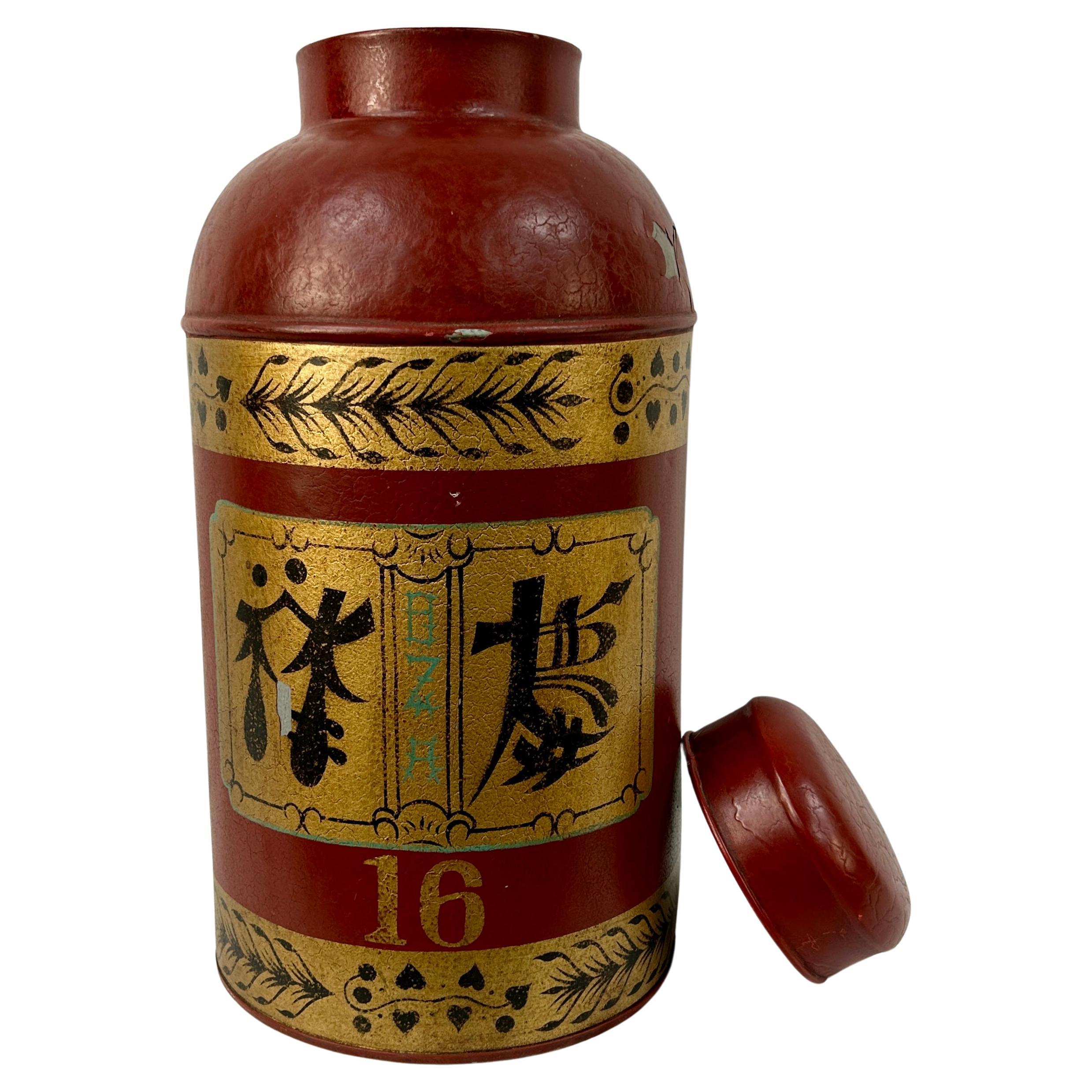 Late 20th Century Chinese Export toleware tea cannister with lid. This tea tin features Chinese characters and is hand painted gold, black and green on a red background. Can be used as a decorative piece or made into a stunning lamp.