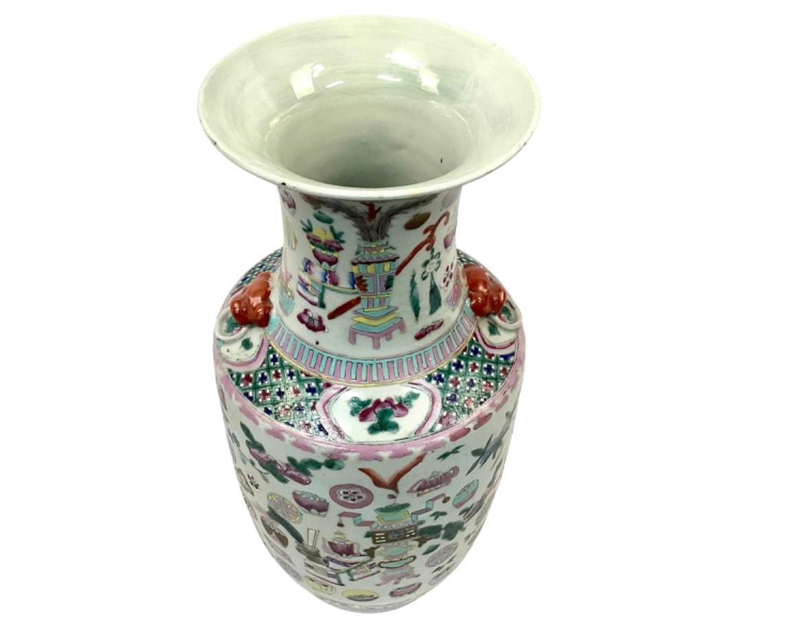 Early 20th century off-white lobed Famille Rose porcelain vase with red foo dog side ornaments. Traditional pink and green bogu pattern featuring leaves and art objects. Mouth opening is 6.75