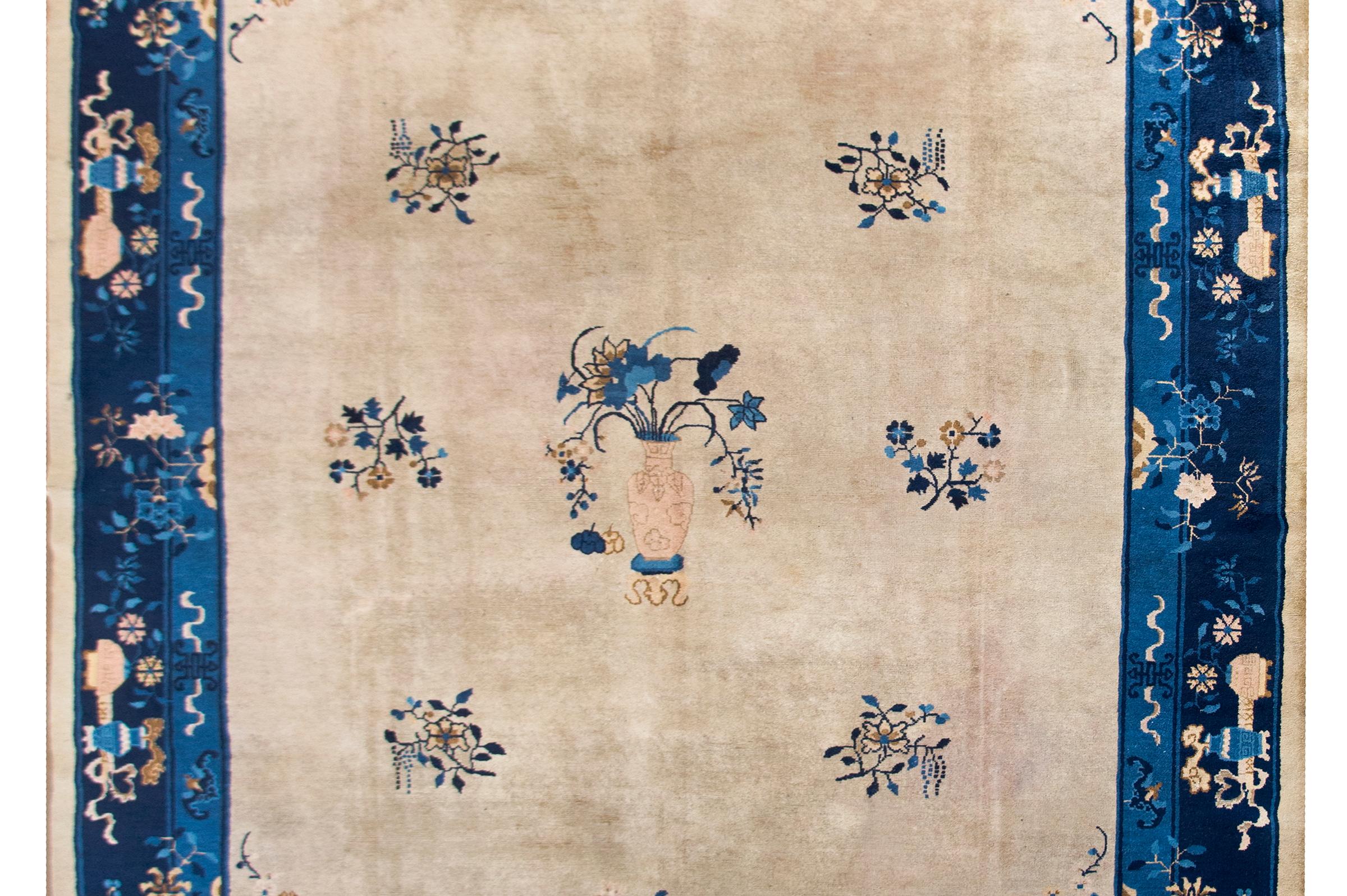 A beautiful early 20th century Chinese Feti rug with a cream colored central field dotted with floral clusters and a large central vase potted with lotus blossoms, and all surrounded by a fantastic border with myriad vases potted with auspicious