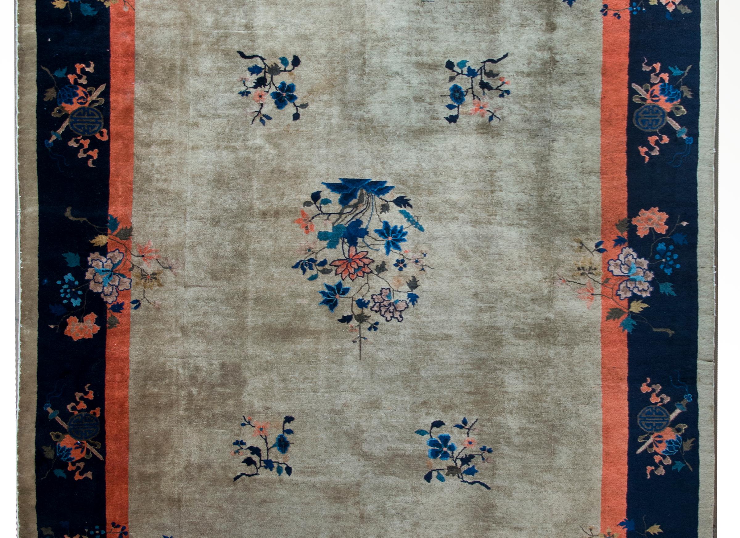 A beautiful early 20th century Chinese Feti rug with a gray field surrounded by a thin orange stripe a wide indigo stripe, and a thin gray striped border, and all overlaid with multi-colored auspicious flower clusters including peonies,