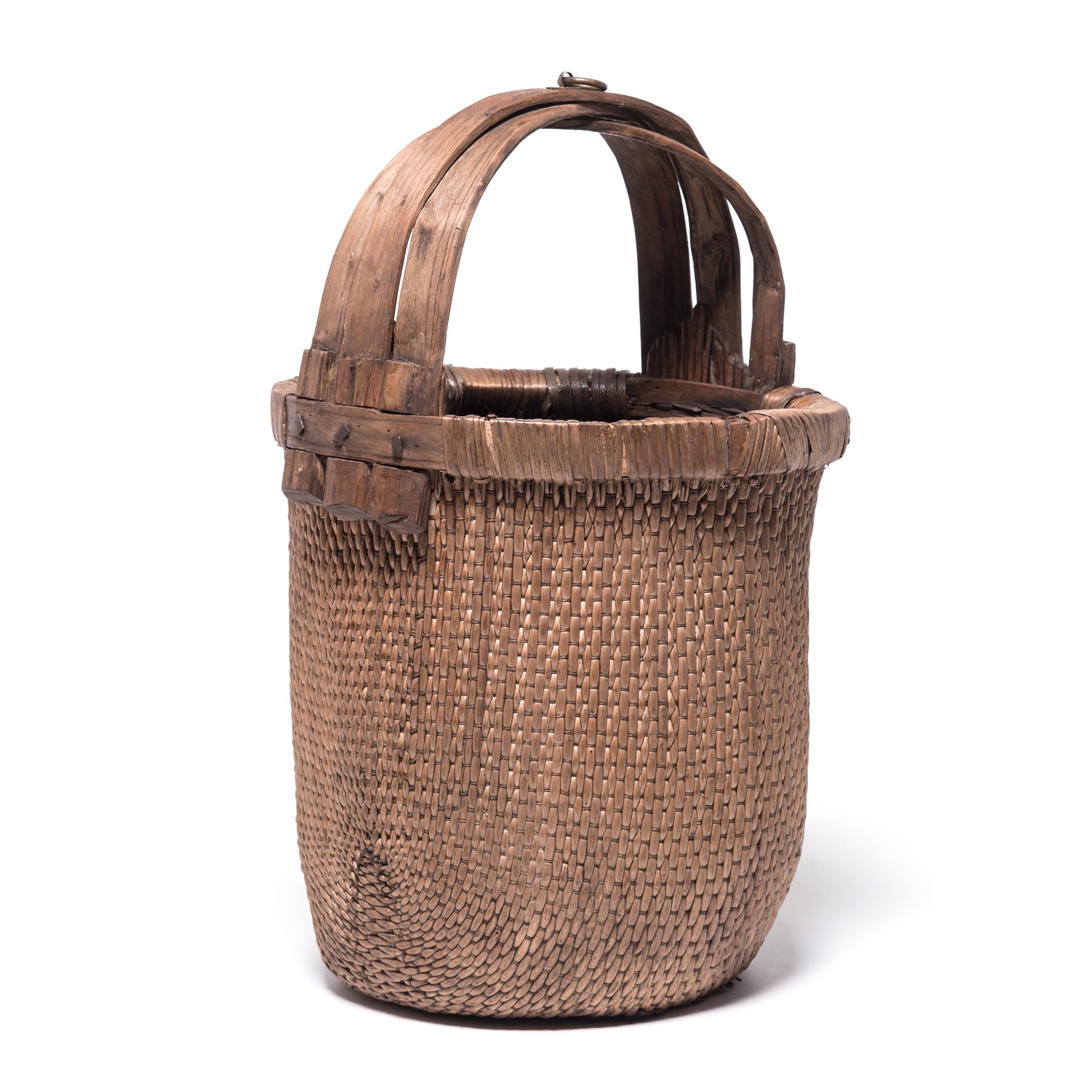 Basket making is an ancient and humble craft, but in the hands of a skilled weaver a simple willow basket becomes a truly beautiful statement. The artisan’s mastery is evident in this early 20th century bent handle basket: the strong, flexible