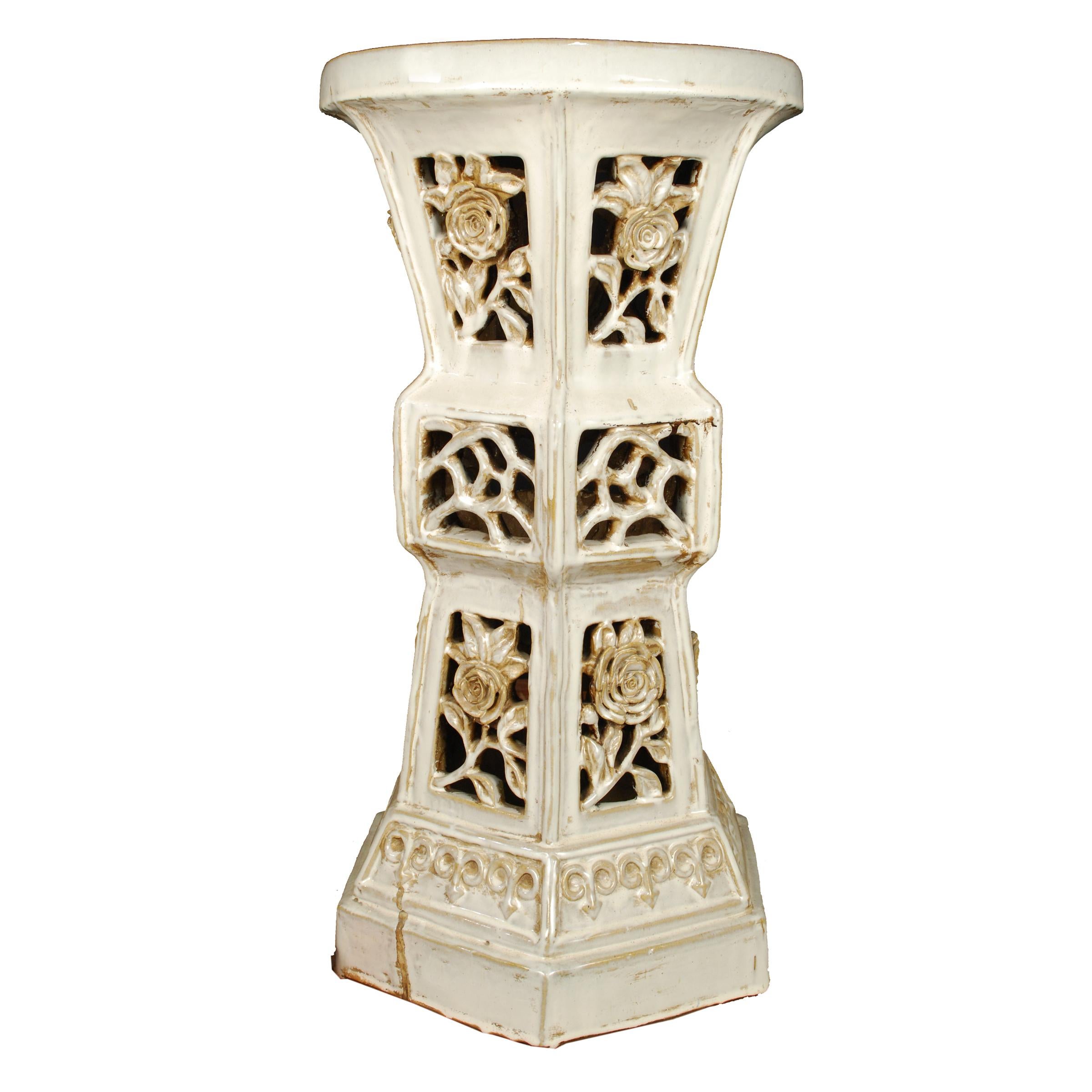 This early 20th century white glazed ceramic pedestal has very unusual form. It was made by an artisan in Southern China and features an hourglass shape and highly dimensional floral cut-outs. It was likely used in a garden for incense, tea or