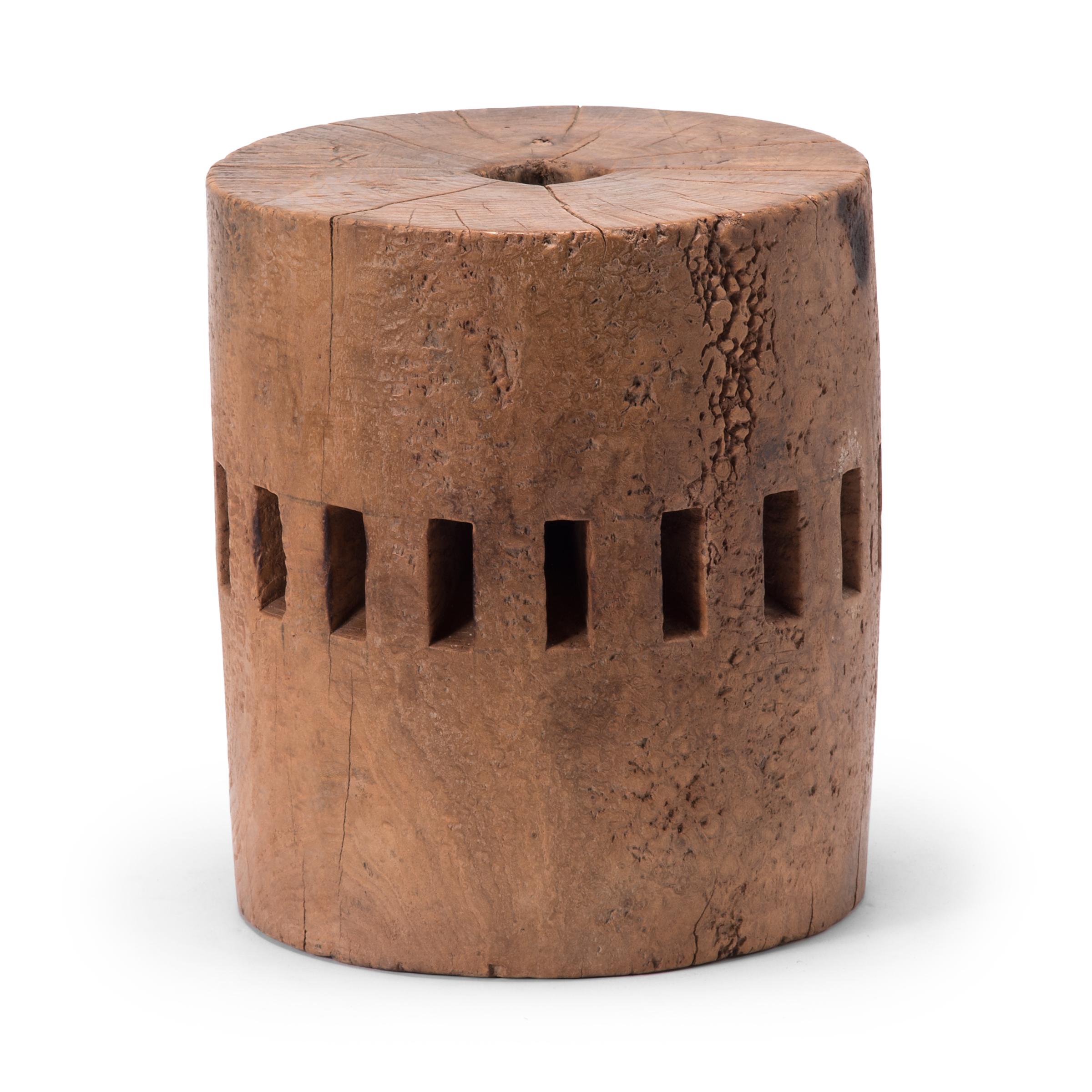 Carved from a single block of fruitwood, this unusual piece was once part of the central wheel shaft of a Qing-dynasty grain mill. Each slot once secured a peg of a large water wheel, which harnessed river currents to draw a millstone across grain