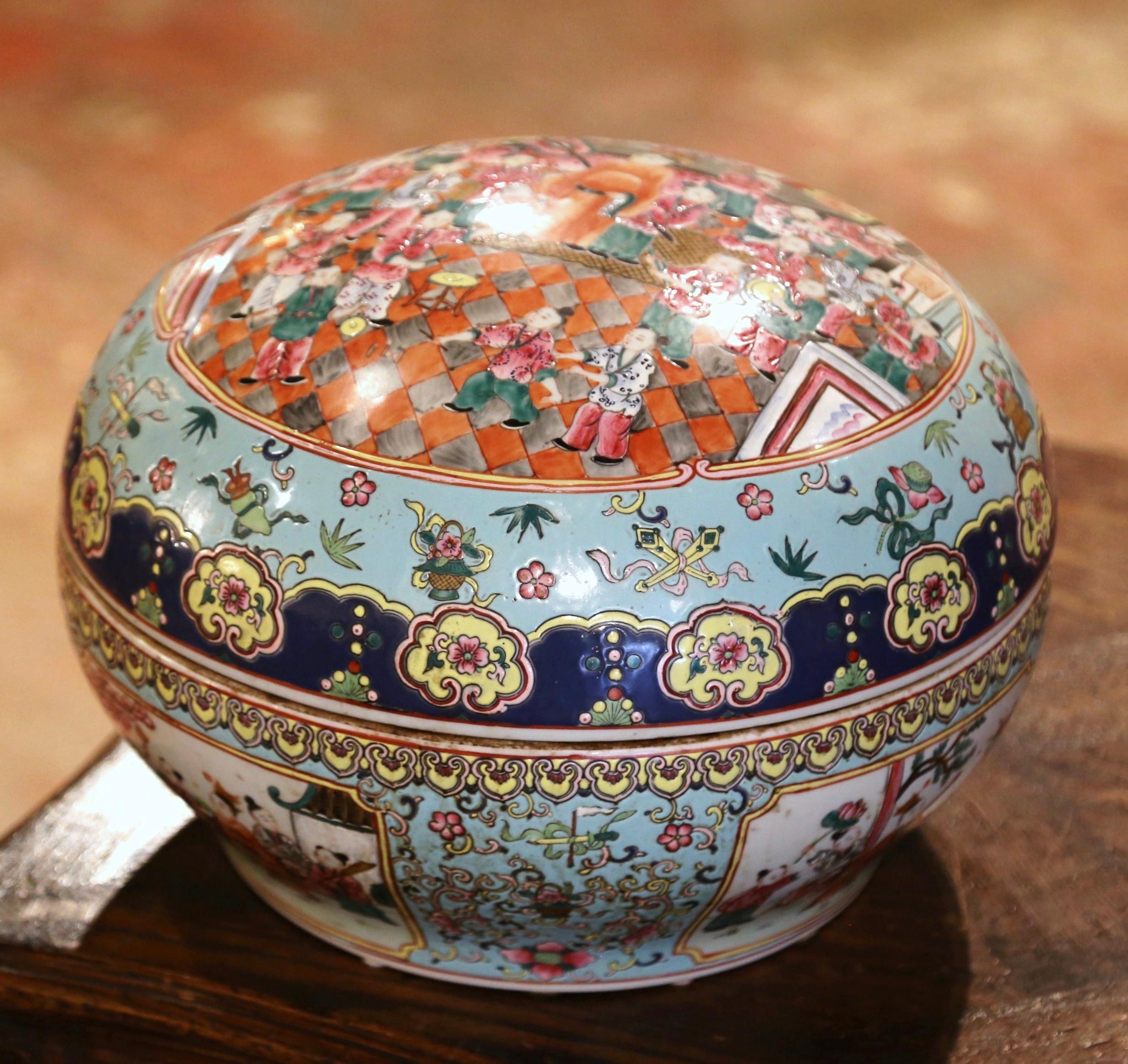 Decorate a table or console with this colorful antique box. Crafted in China circa 1920 and round in shape, the large Guangxu box opens in the center and features different hand painted scenes throughout; it is further embellished with hand painted