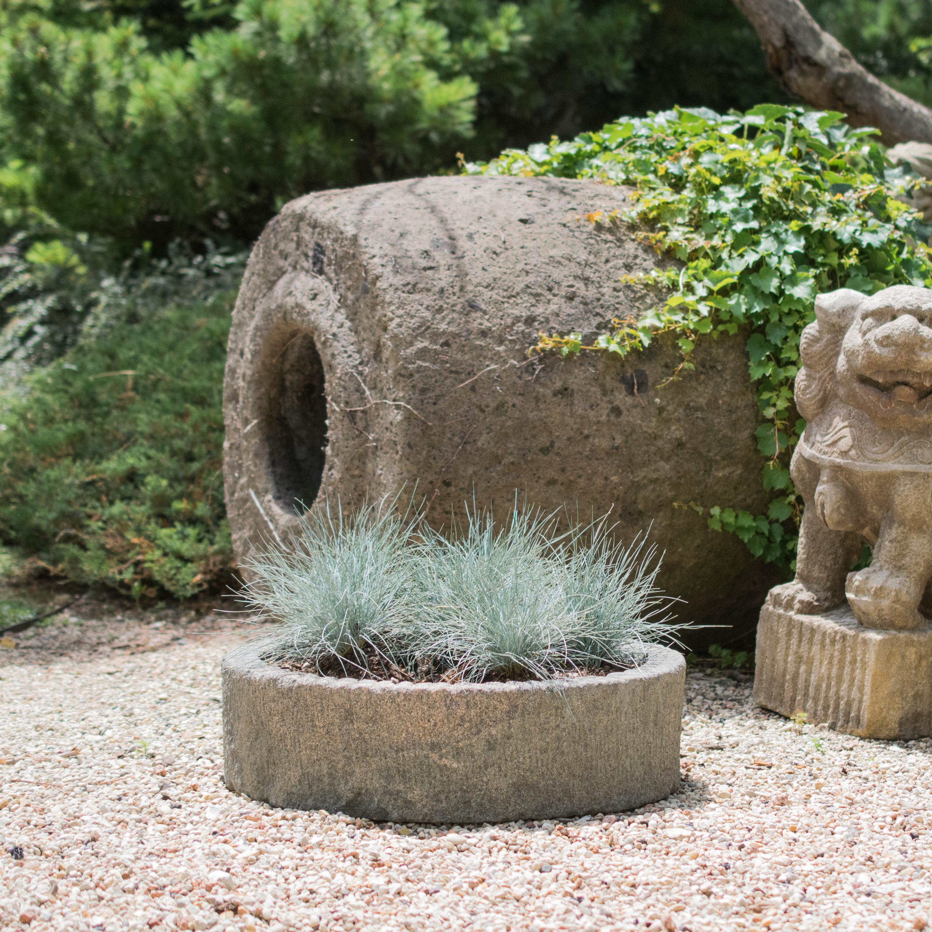 This millstone was hand-carved over 100 years ago in Northern China out of a single block of limestone. It shows signs of wear that add wonderful character and attest to its age and use—grinding rice or other grains. China is famous for its