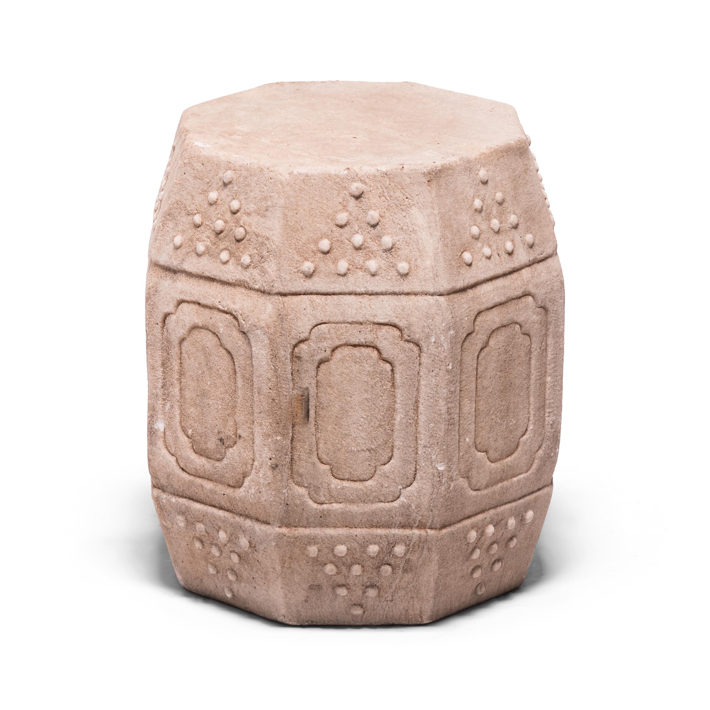 Hand carved of solid marble, this early 20th century drum-form stool has eight sides, an auspicious number symbolizing good fortune and prosperity. Each side is decorated with a simple yet effective design of nested cartouche panels and imitation