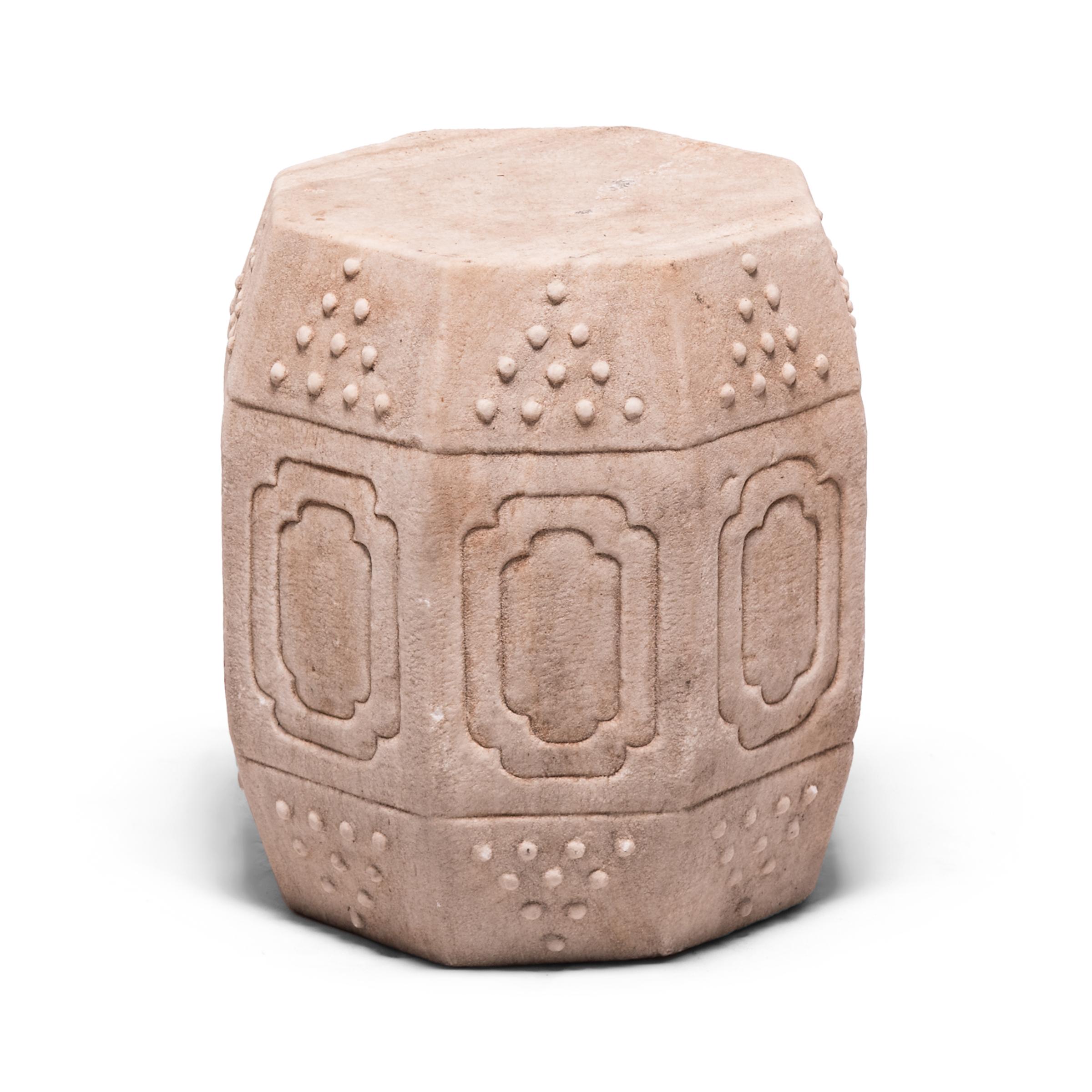 Hand carved of solid marble, this early 20th century drum-form stool has eight sides, an auspicious number symbolizing good fortune and prosperity. Each side is decorated with a simple yet effective design of nested cartouche panels and imitation