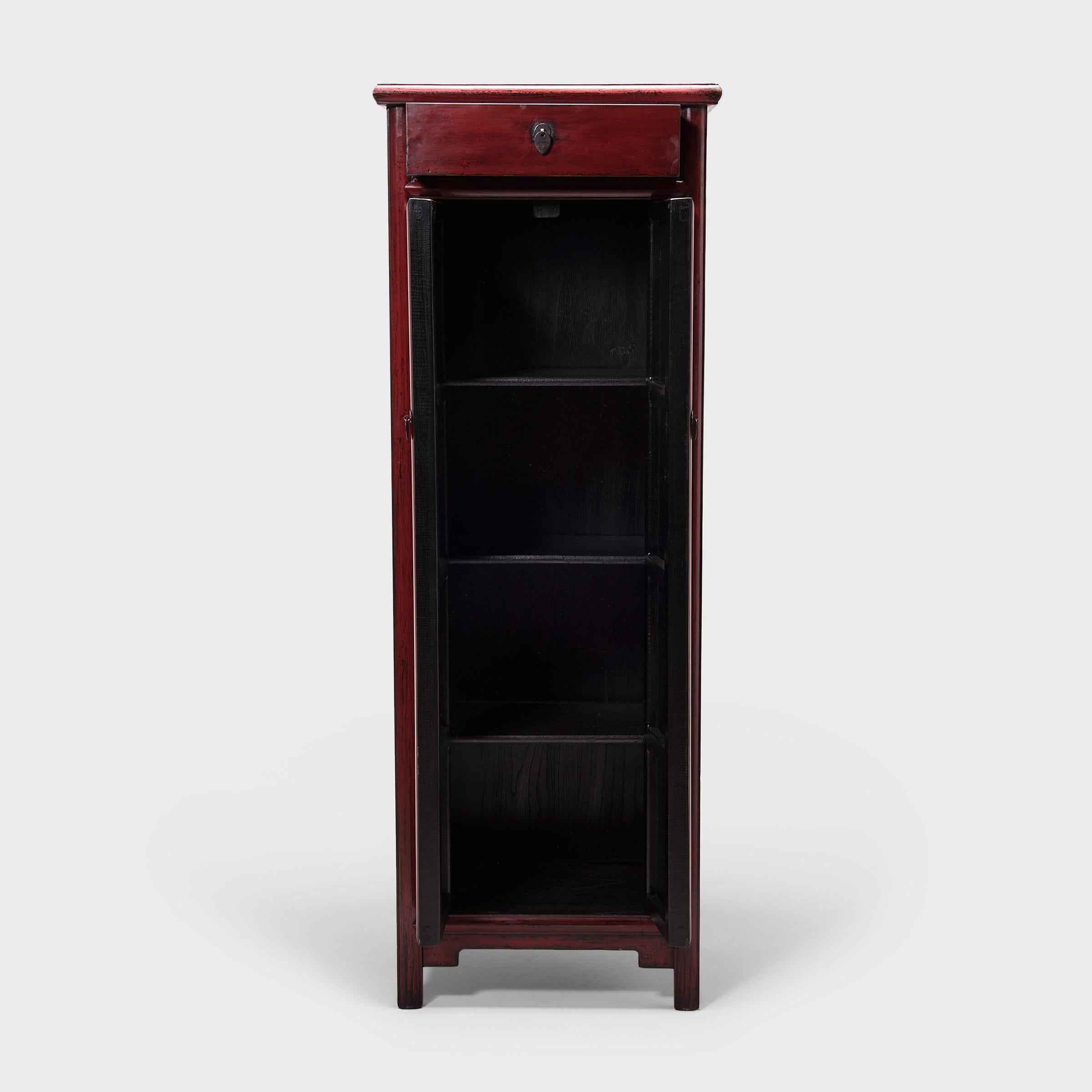 Constructed in China's Hebei province, this early 20th century noodle cabinet is unusual for its tall, narrow stature. Known as a “noodle cabinet” for the rounded wood molding that outlines its doors, the cabinet has a timeless design, with clean