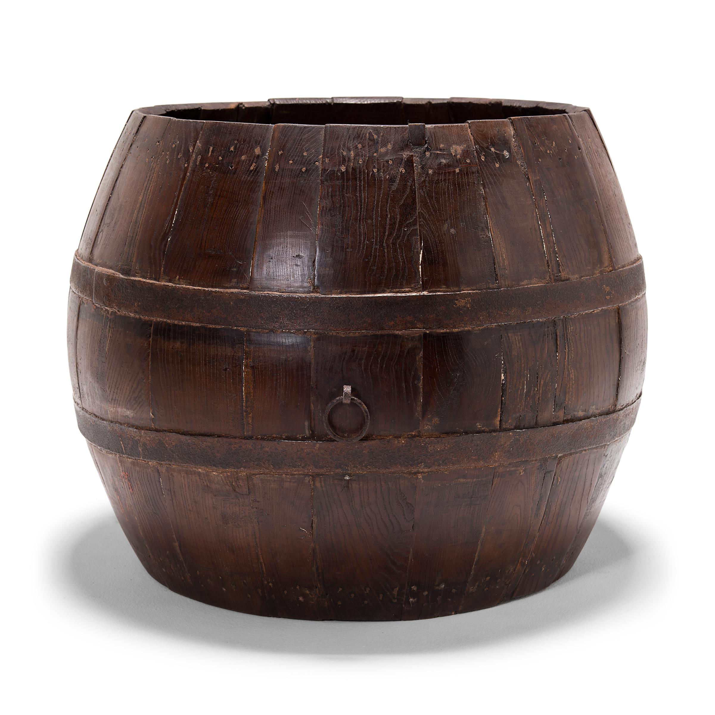 This squat, melon-like barrel is actually a turn of the century Peking opera drum, originally used by a theater troupe to accompany the dances and songs of traditional Chinese opera. The drum's finely joined oakwood slats are held together by