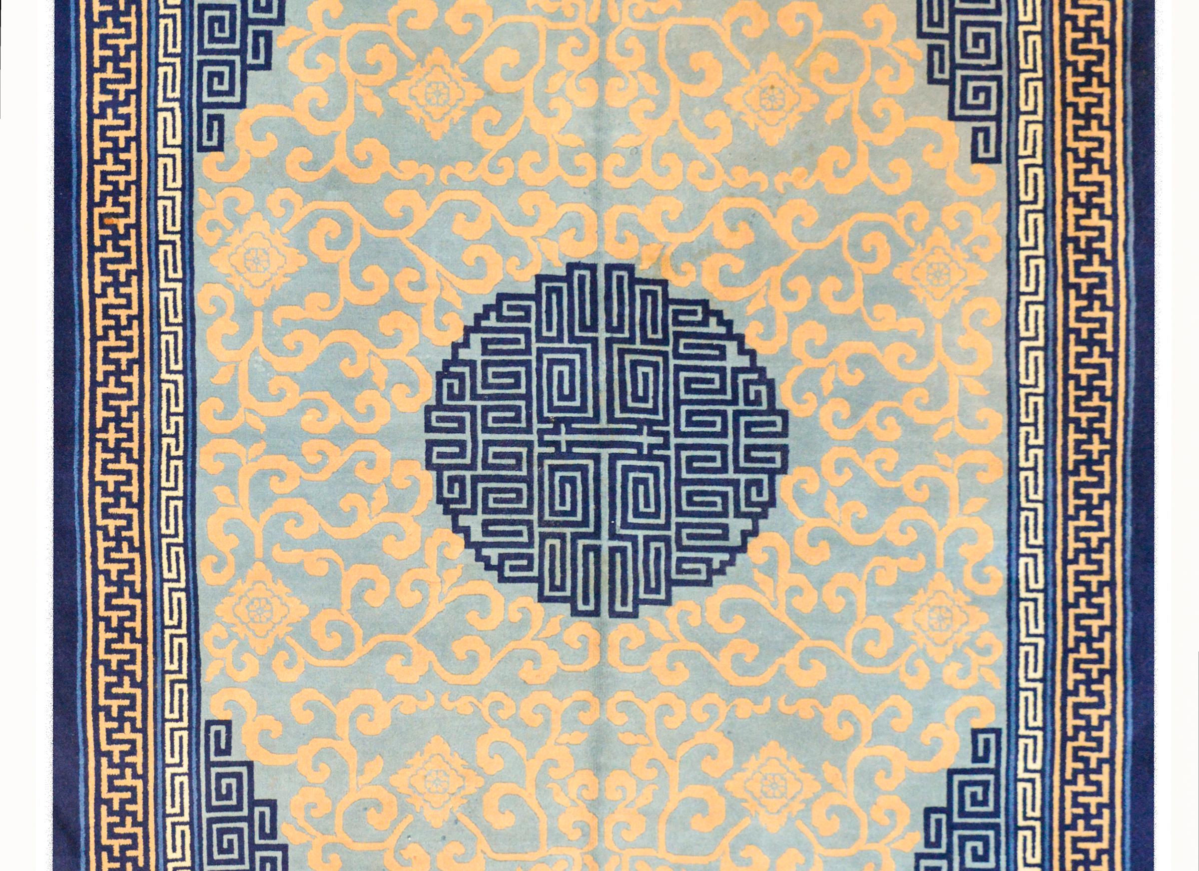Magnifique tapis chinois de Pékin du début du XXe siècle avec un grand personnage rond stylisé Shuo, symbolisant la prospérité, au milieu d'un champ de vignes défilantes, et entouré d'une bordure complexe contenant plusieurs motifs sinueux de styles