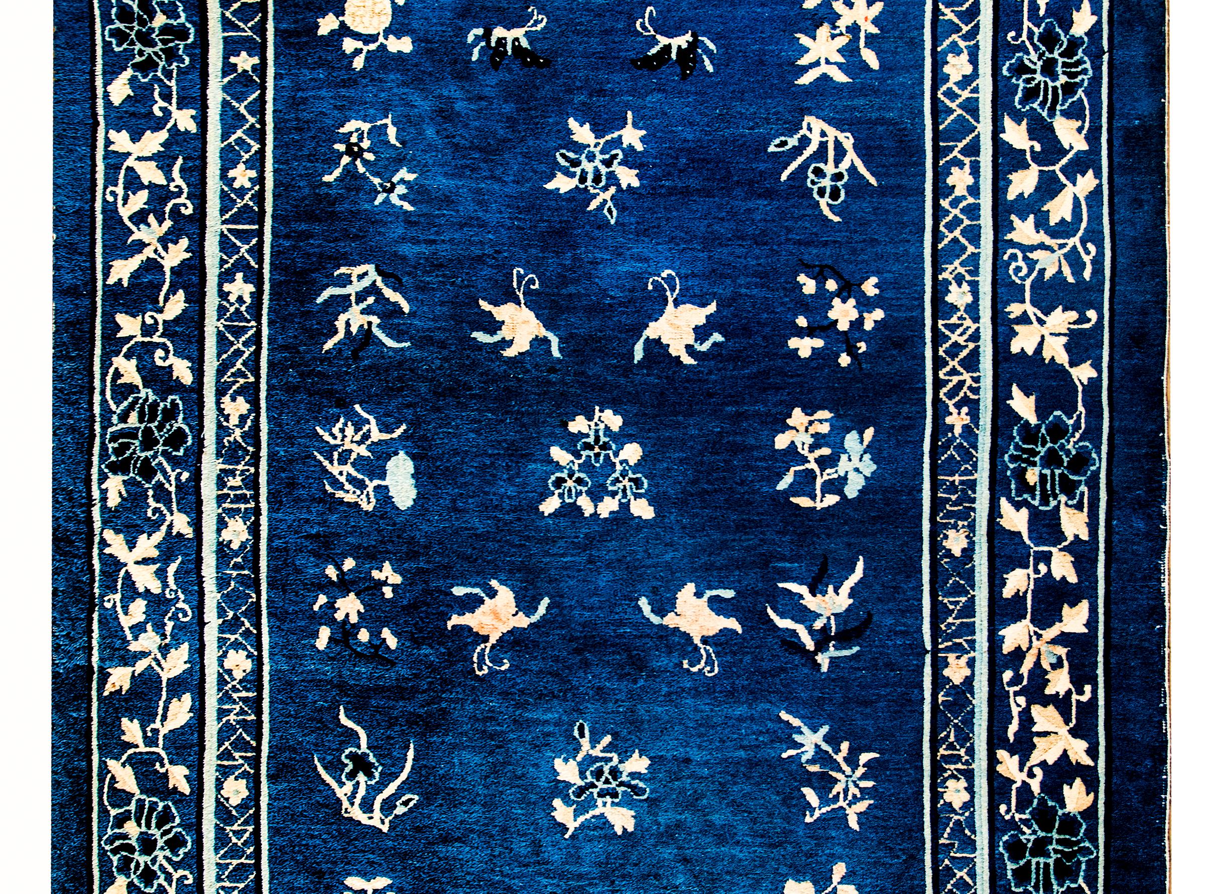 Magnifique tapis chinois de Pékin du début du XXe siècle à motif floral rose et crème sur fond indigo foncé, entouré d'une bordure simple à motif floral et de vigne, avec une bande intérieure à motif de glace craquelée et floral.