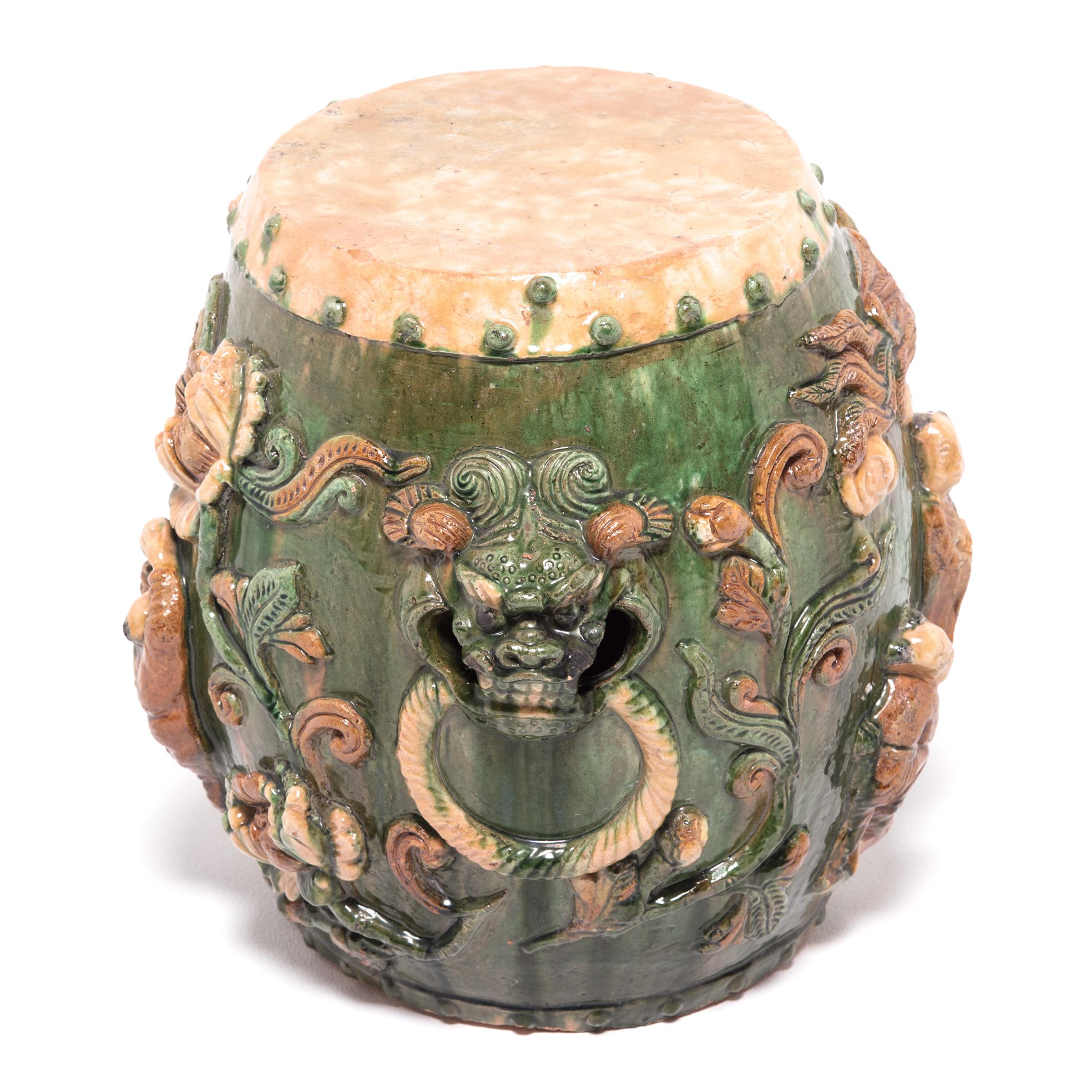 Ornately decorated in high relief, this ceramic drum stool is an expressive example of sancai, or “three colors,” ware. This technique was developed during the Tang dynasty and typically combines green, cream and amber glazes. During firing, the