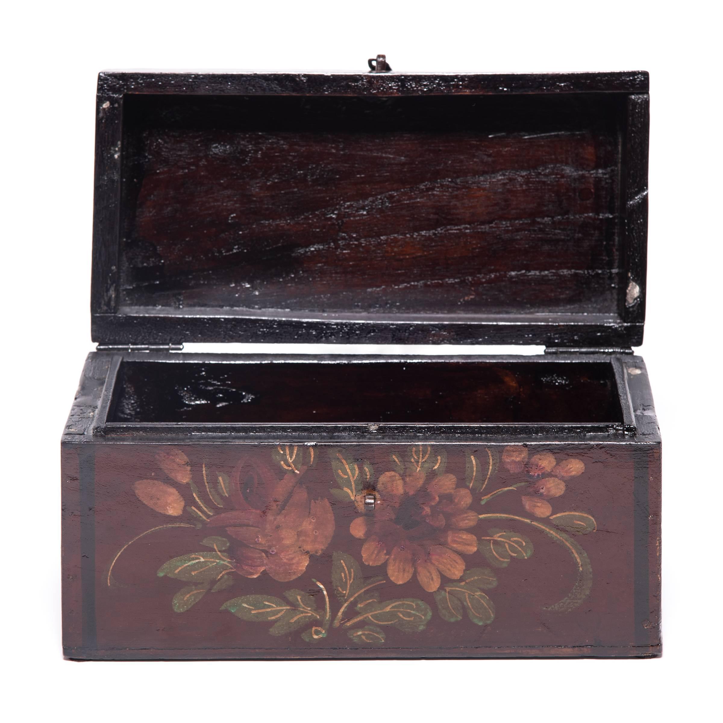 Made of humble pine, this simple box was transformed by coats of rich lacquer and decorative painted motifs to become a fitting container for treasured objects. Crafted circa 1900, this treasure box is adorned with a bouquet of peonies, a sign of